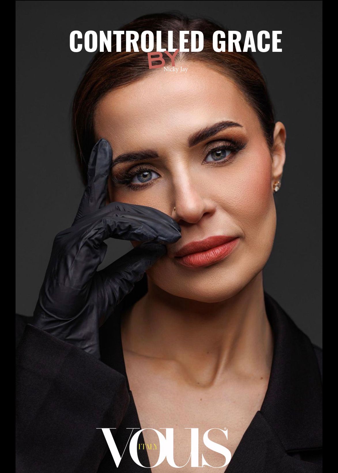 Elegant woman in black jacket with gloved hand near face on VOUS magazine Controlled Grace cover.