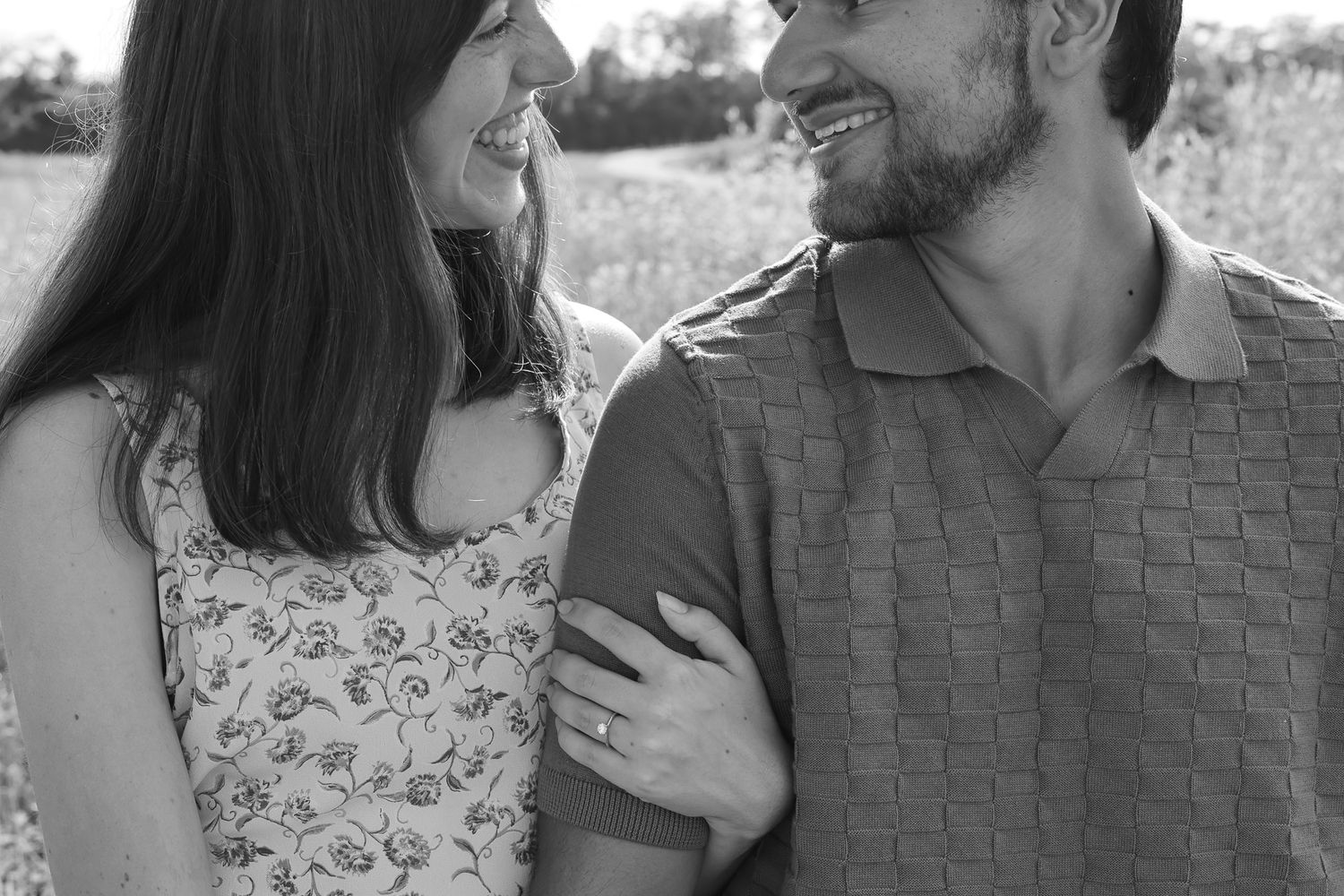 A couple shares intimate moments in black and white portraits against a natural backdrop.