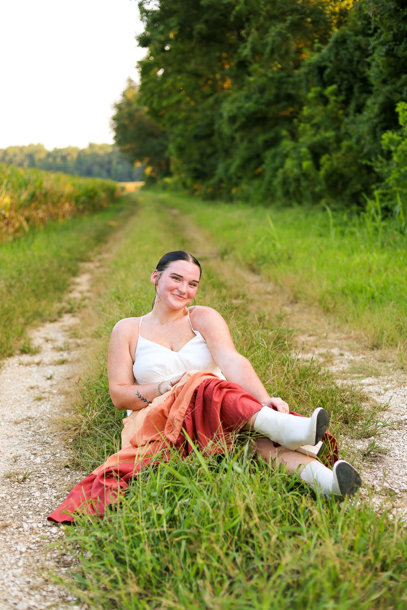 Relaxed outdoor portrait on grassy path with late afternoon lighting.