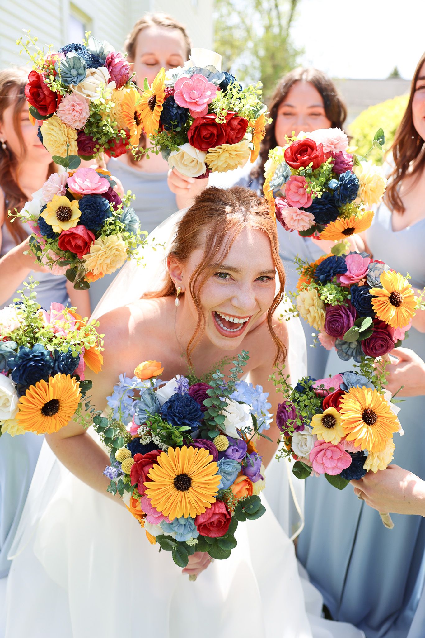 Colorful floral crowns featuring sunflowers and mixed blooms worn at a wedding celebration.