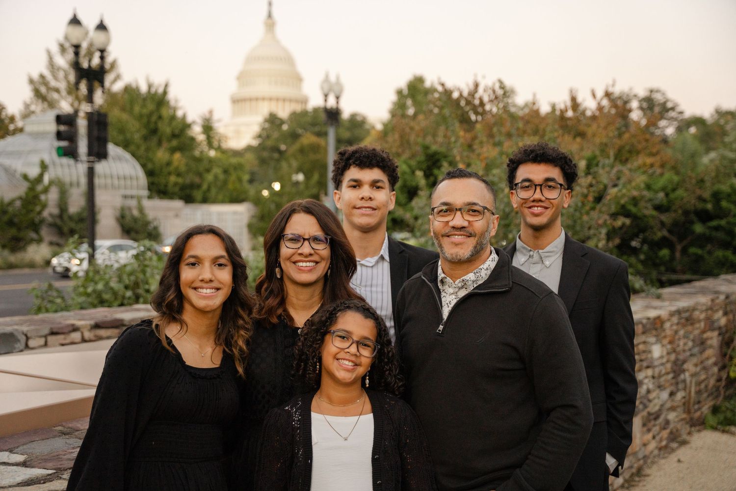 A series of professional family photos taken outdoors with the US Capitol building visible in the background.