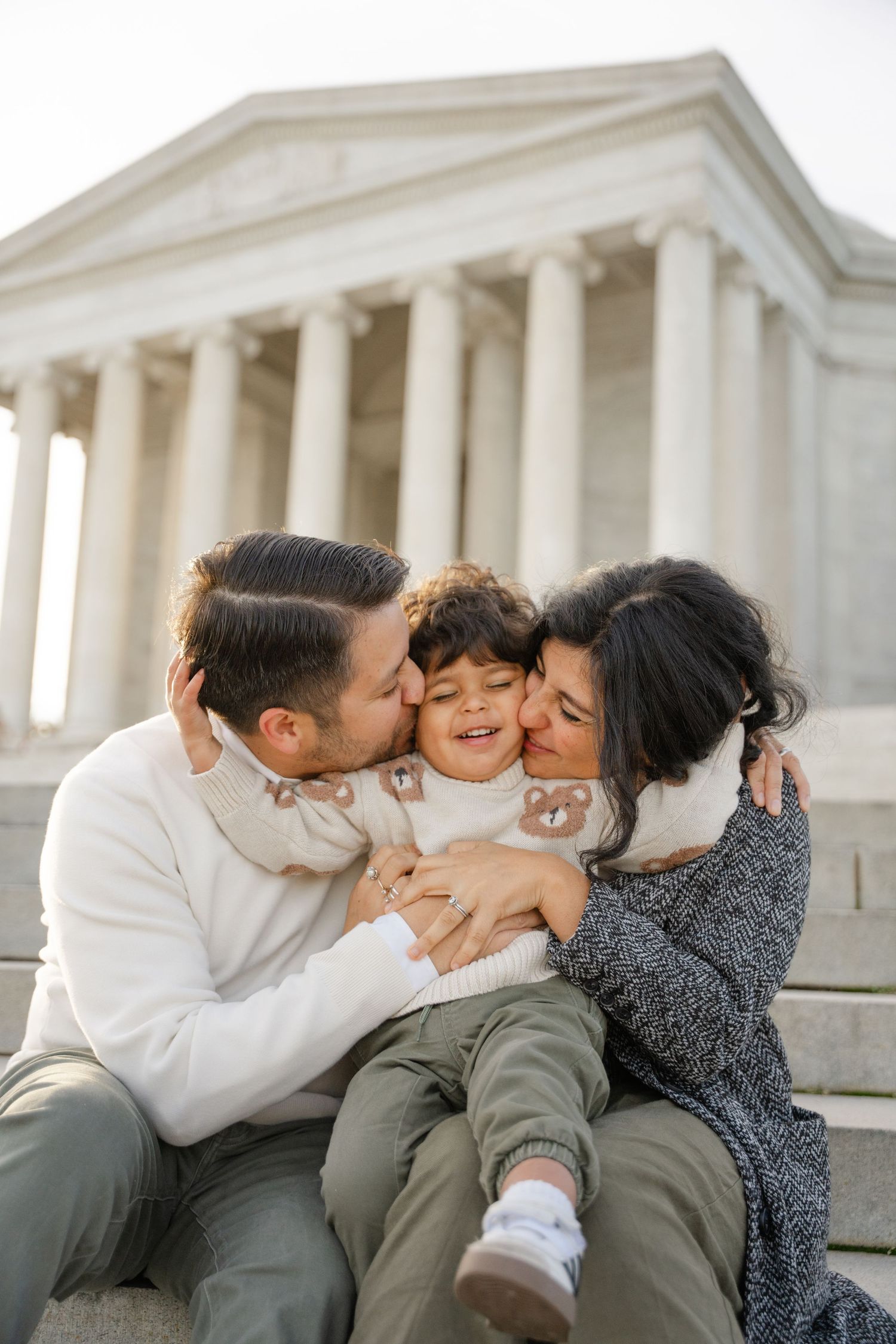 Family shares tender moment together while sitting at the Jefferson Memorial in Washington DC.