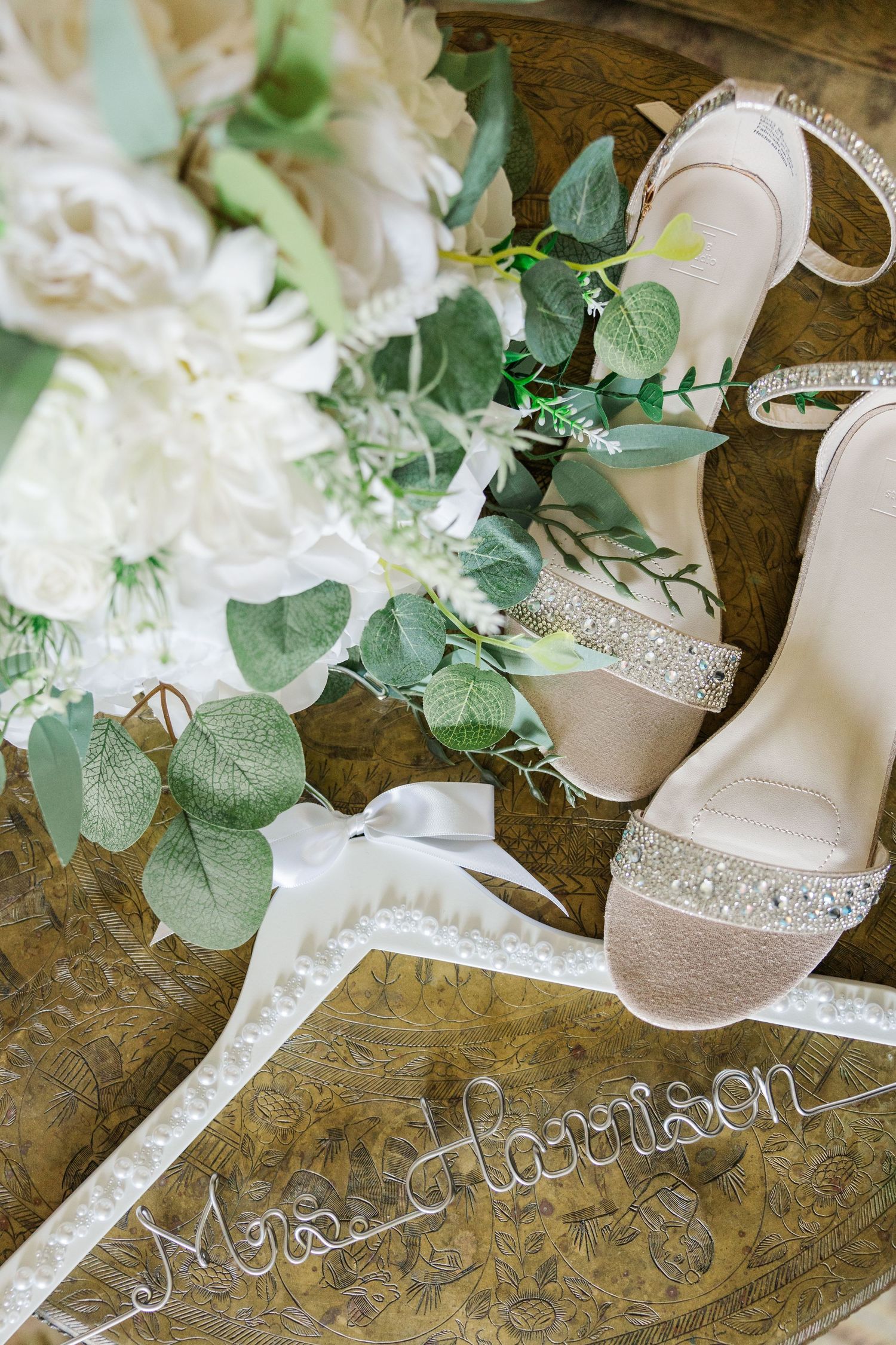 Detailed Wedding Photography depicting the bride's bouquet, shoes and dress hanger.