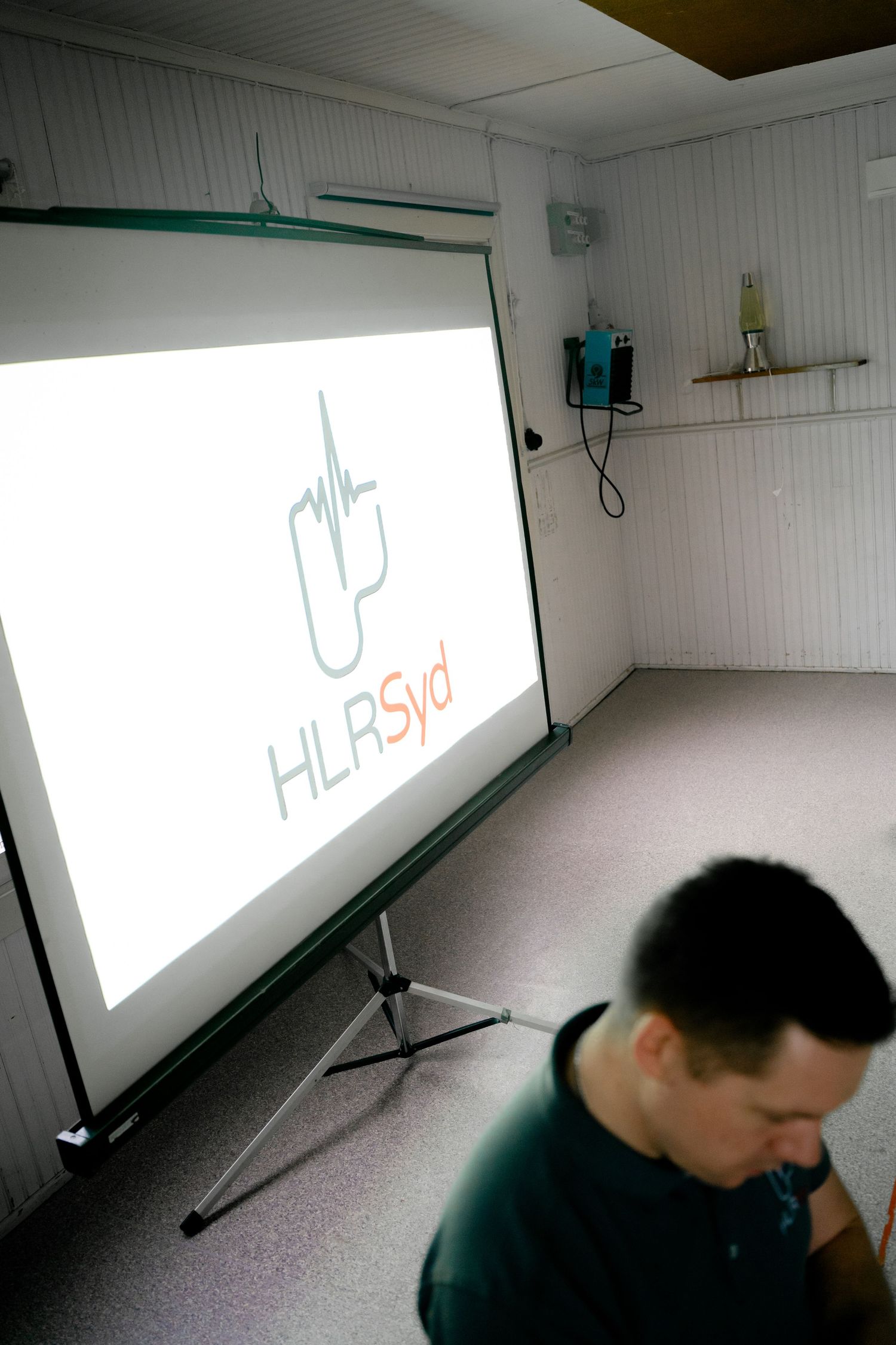 Training room setup with projector screen displaying company logo.