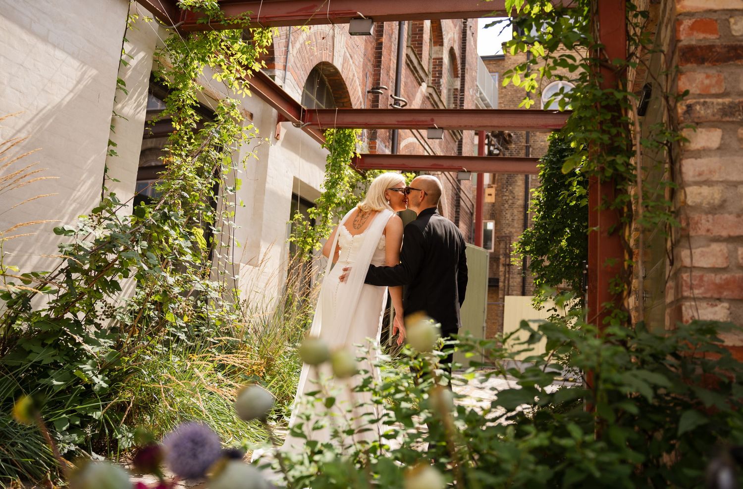 A romantic wedding moment in an old courtyard with ivy-covered walls and classic architecture.