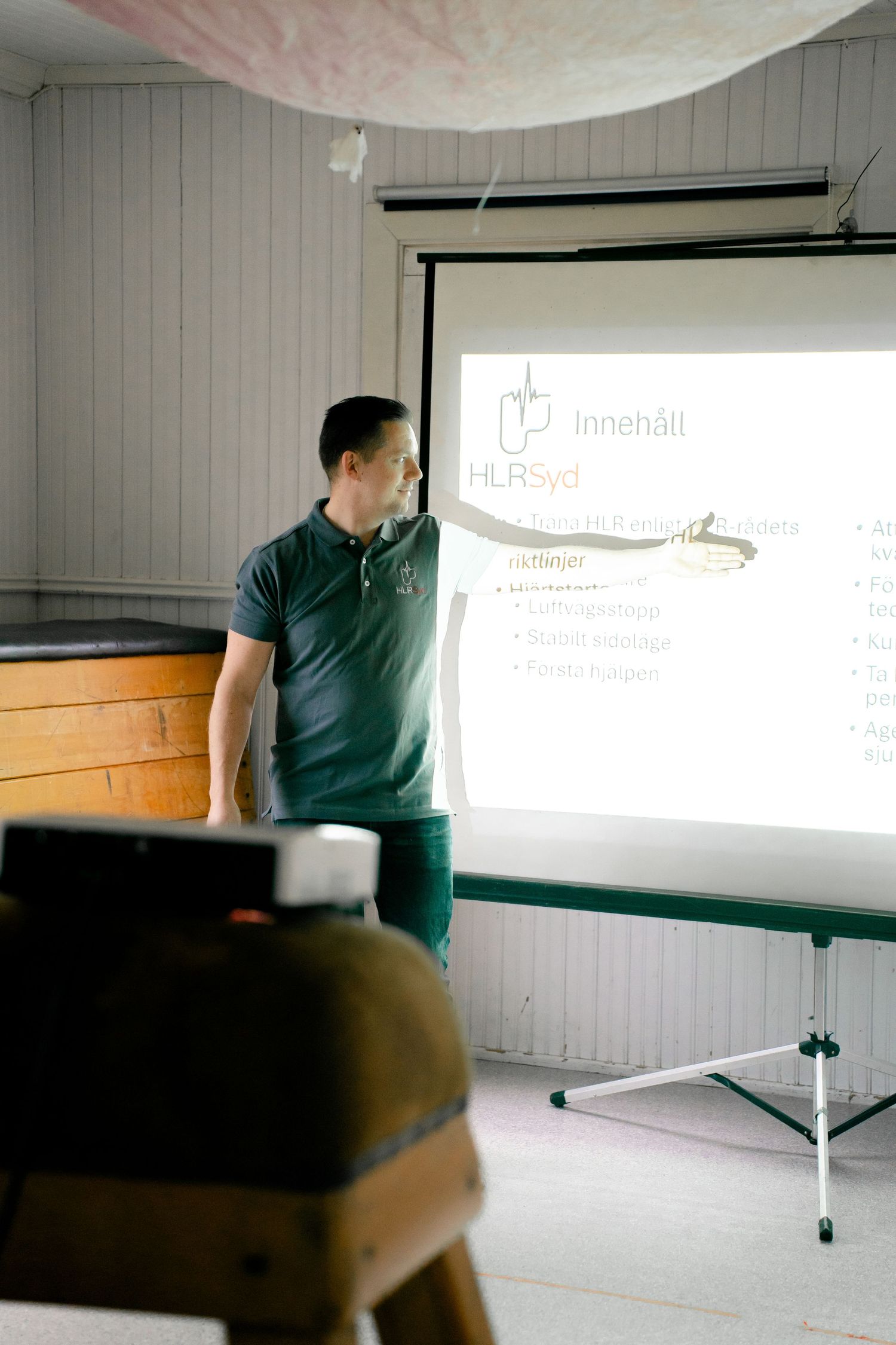 Instructor pointing at projection screen during training presentation.