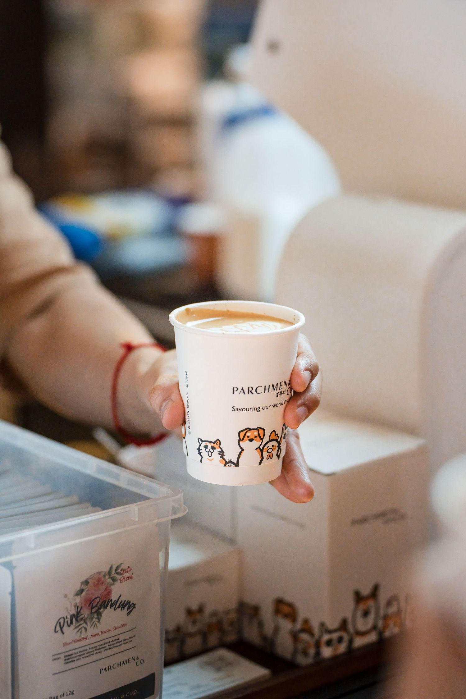 Barista handing over completed coffee drink to customer