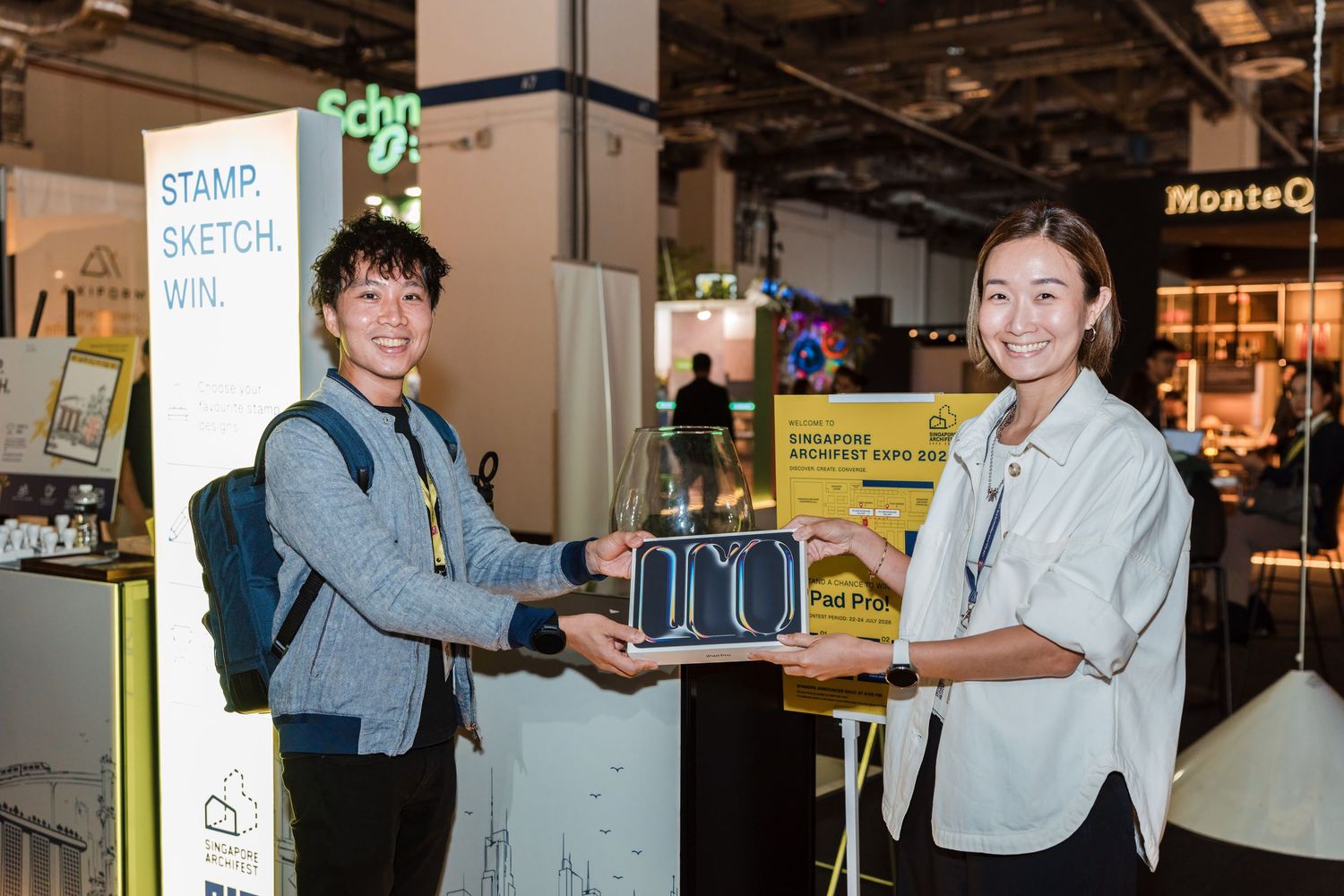 Winner receiving iPad Pro prize at giveaway during exhibition