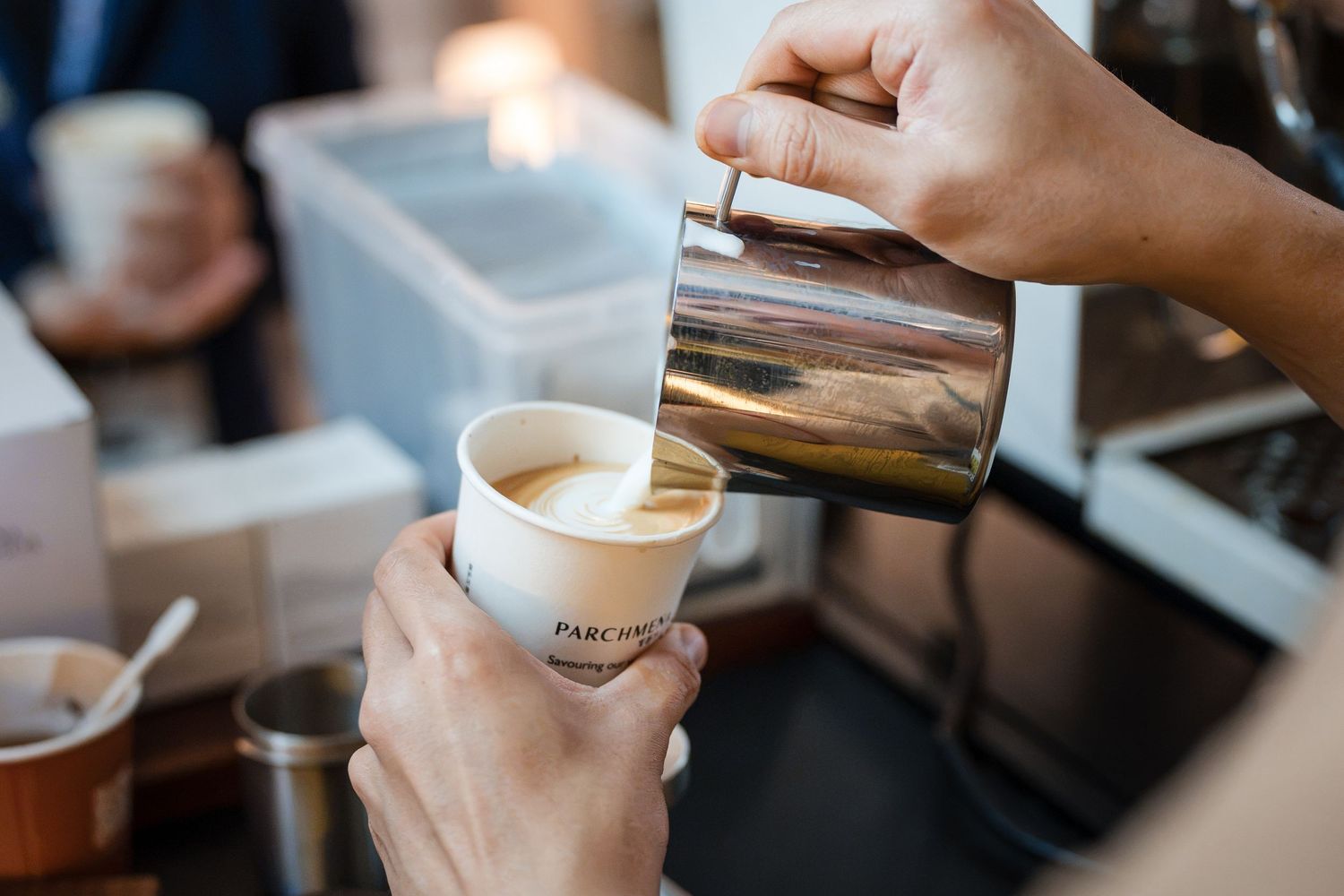 Barista pouring milk into coffee during event