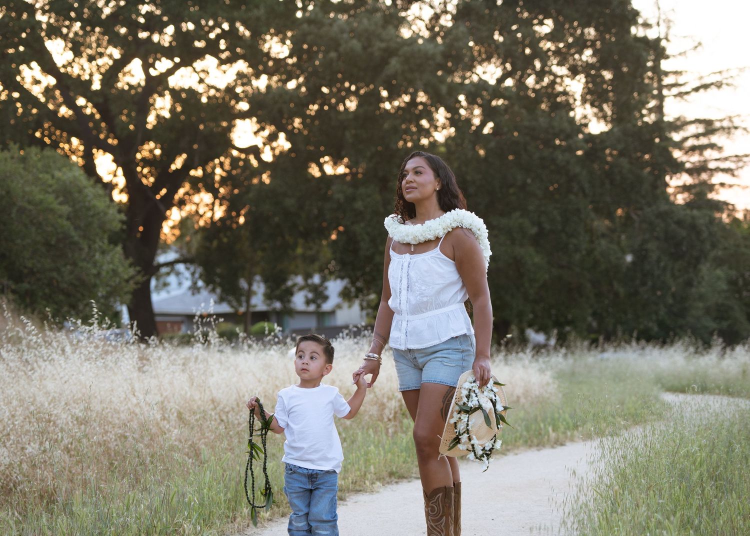 Kiana modeling a white lei lineup alone side her son, Kaimana