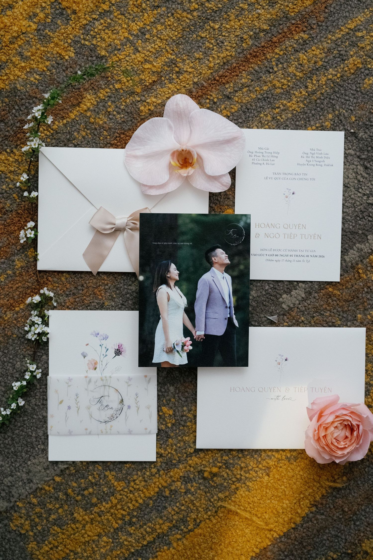 Elegant wedding invitation suite with floral accents, featuring a couple photo, pink roses, and orchid on mossy background.