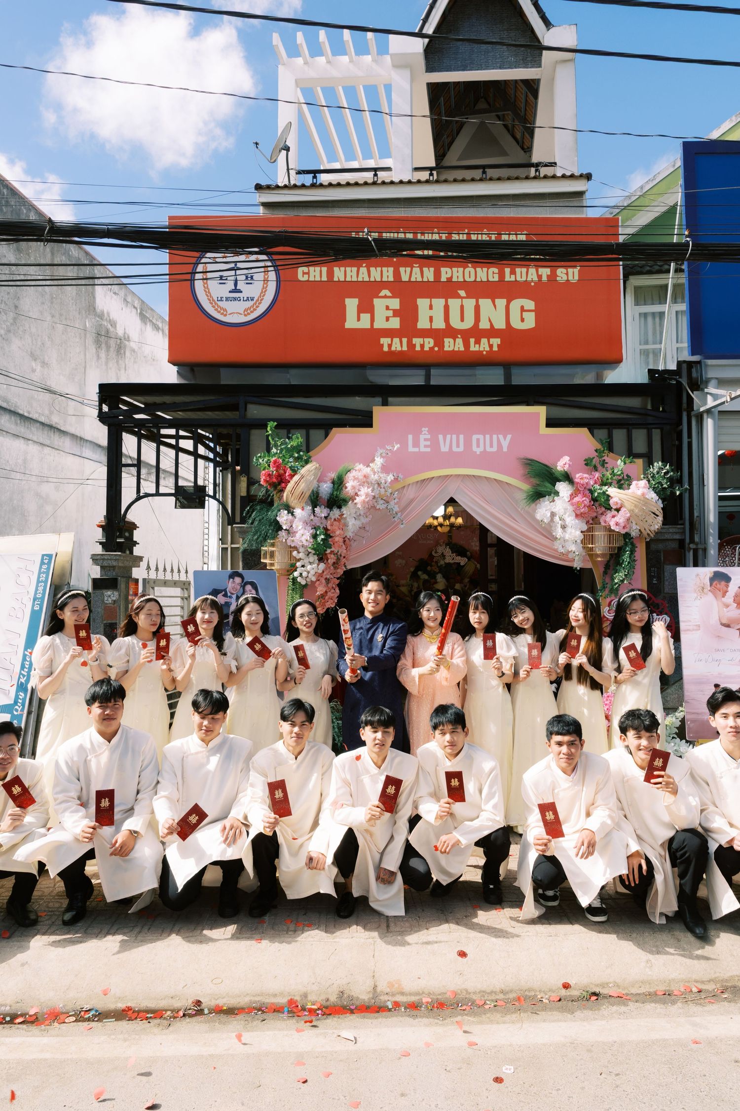 Vietnamese wedding party group photo outside Le Hung law office in Da Lat, couples in traditional ao dai.