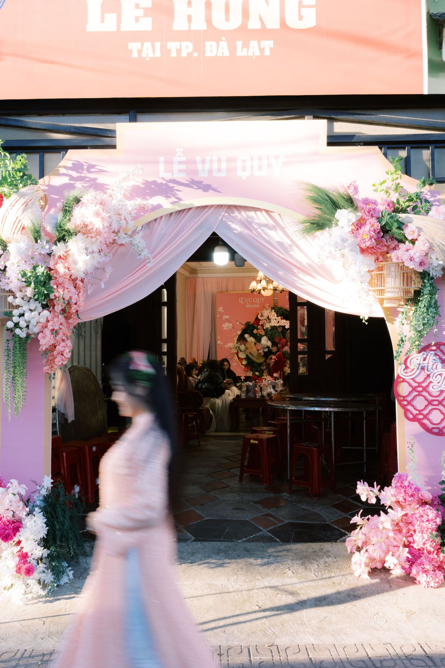 Decorated wedding venue entrance in Da Lat Vietnam with pink floral arch and Le Vu Quy signage.