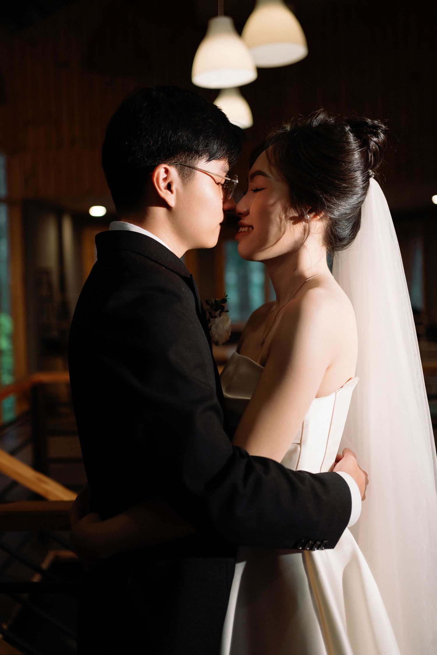 Romantic close-up of a couple in wedding attire sharing an intimate moment indoors.