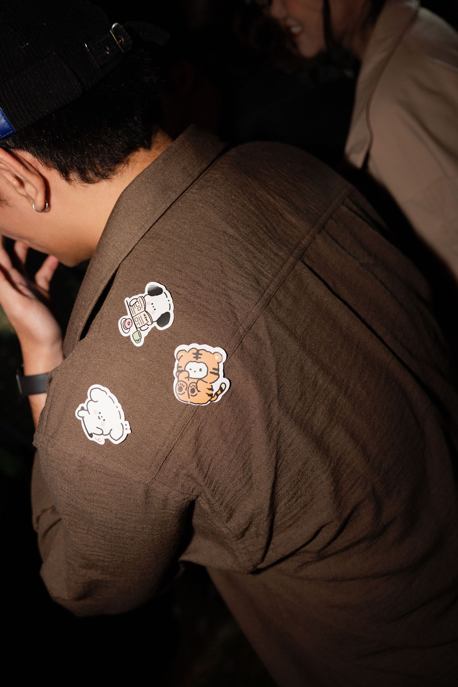 Close-up of brown jacket with cute cartoon bear and Snoopy stickers at wedding party.