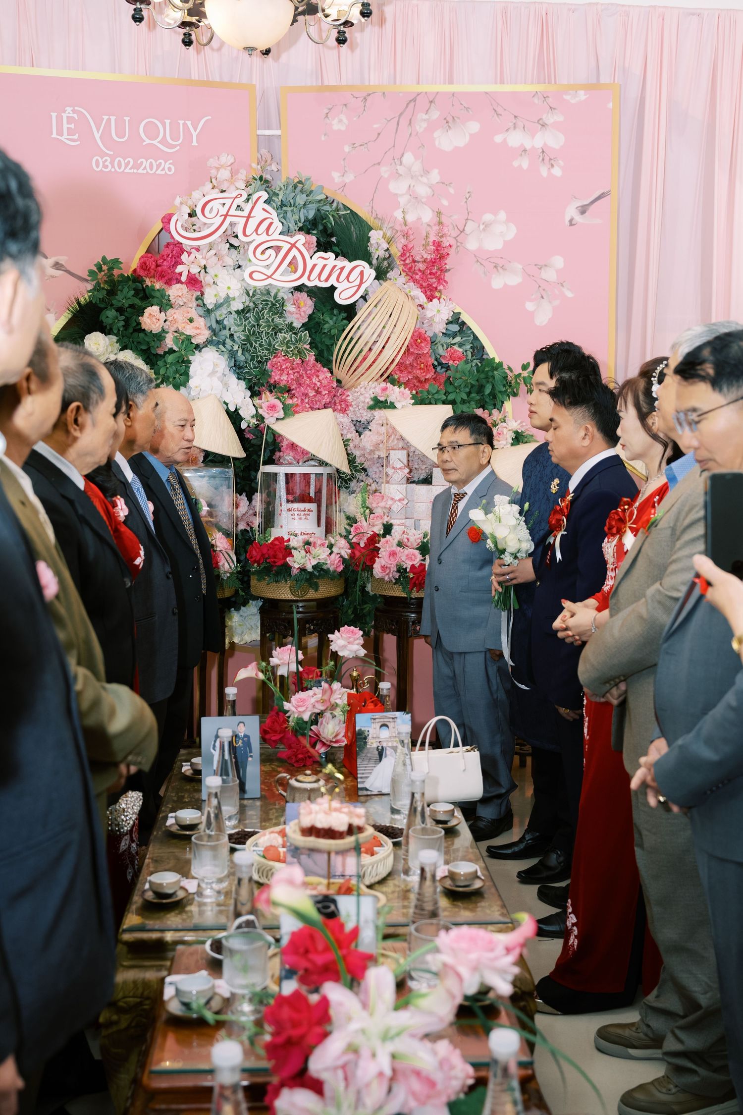 Traditional Vietnamese engagement ceremony Le Vu Quy with guests gathered around decorated altar table.