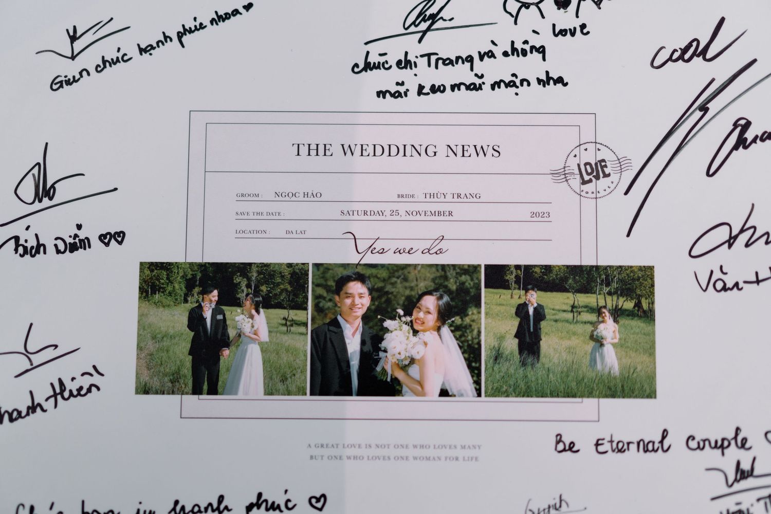 A wedding news sign surrounded by guest signatures and a couple's photo.