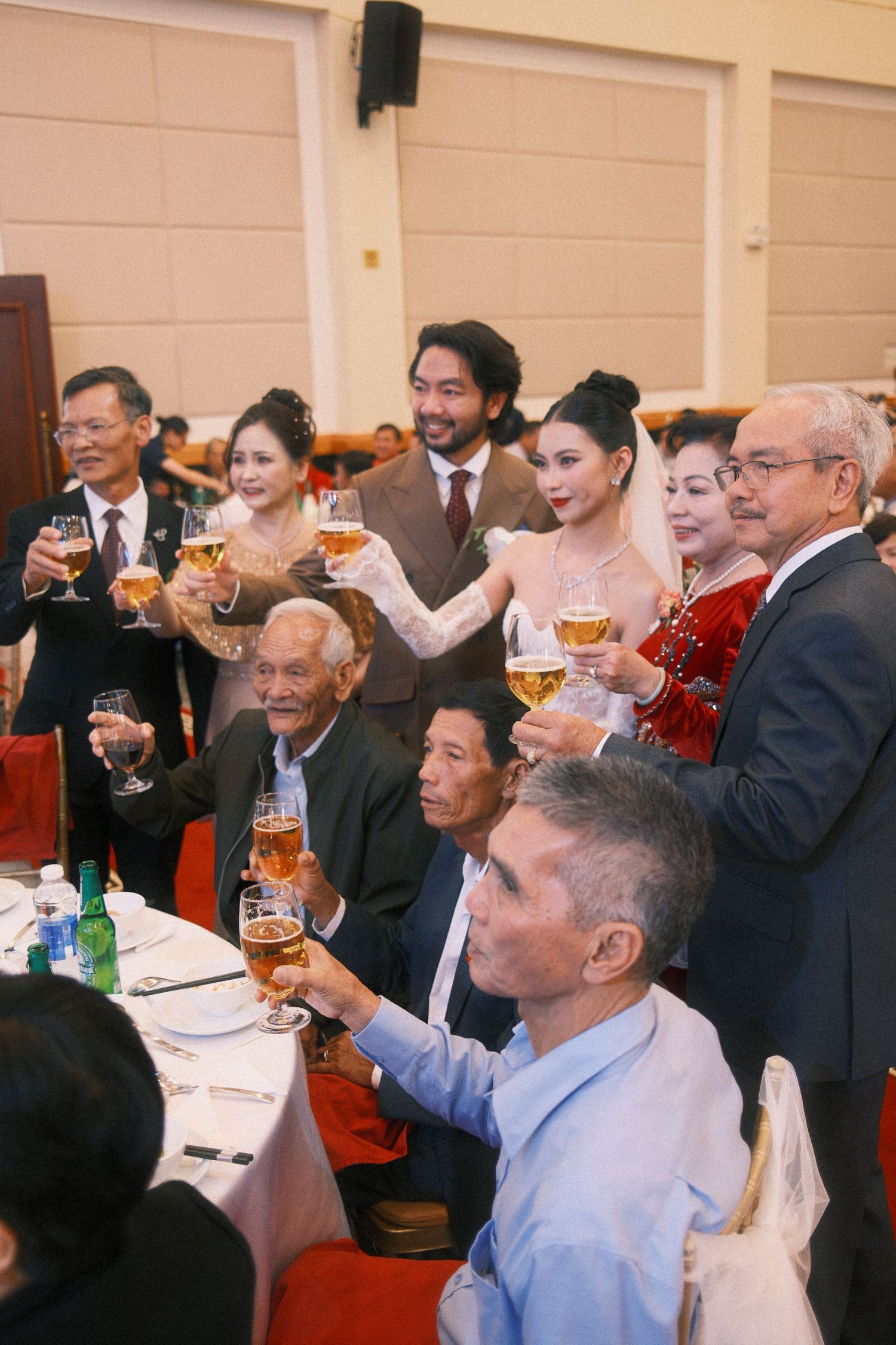 Group of people toasting with champagne glasses at a formal banquet celebration event.