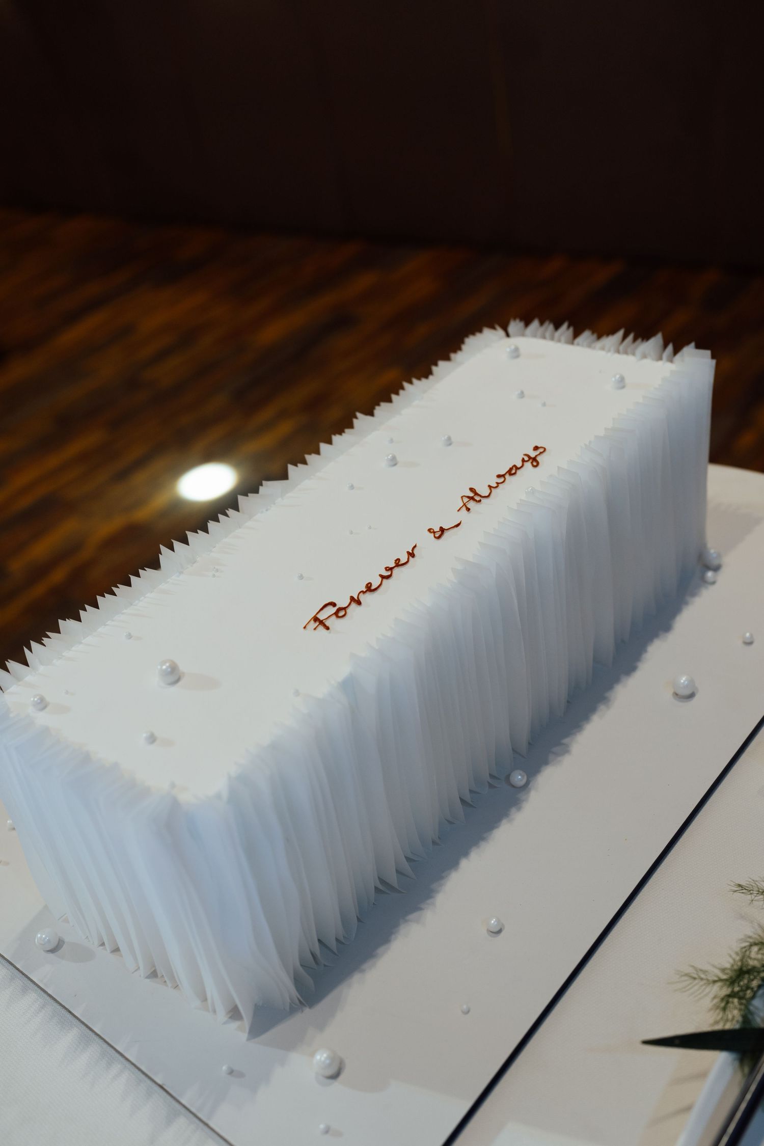 Elegant white rectangular wedding cake with textured frosting and 