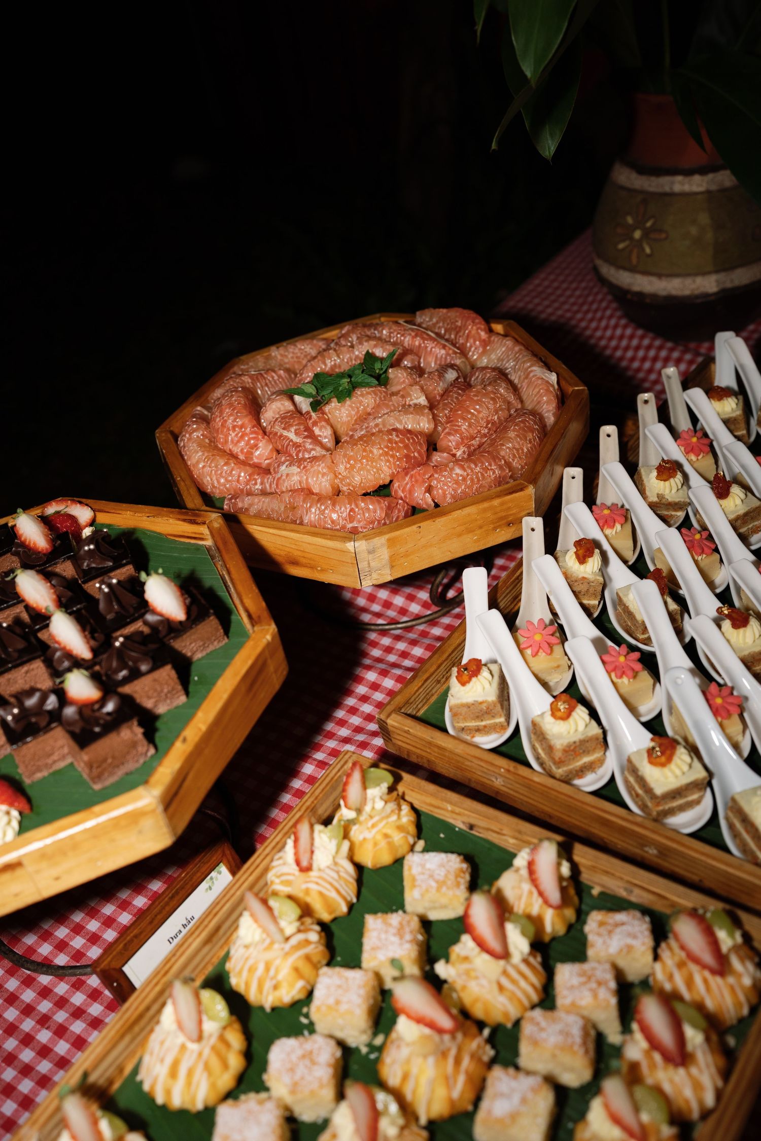 Wedding catering spread featuring sausages, chocolate brownies, strawberry desserts and petit fours.