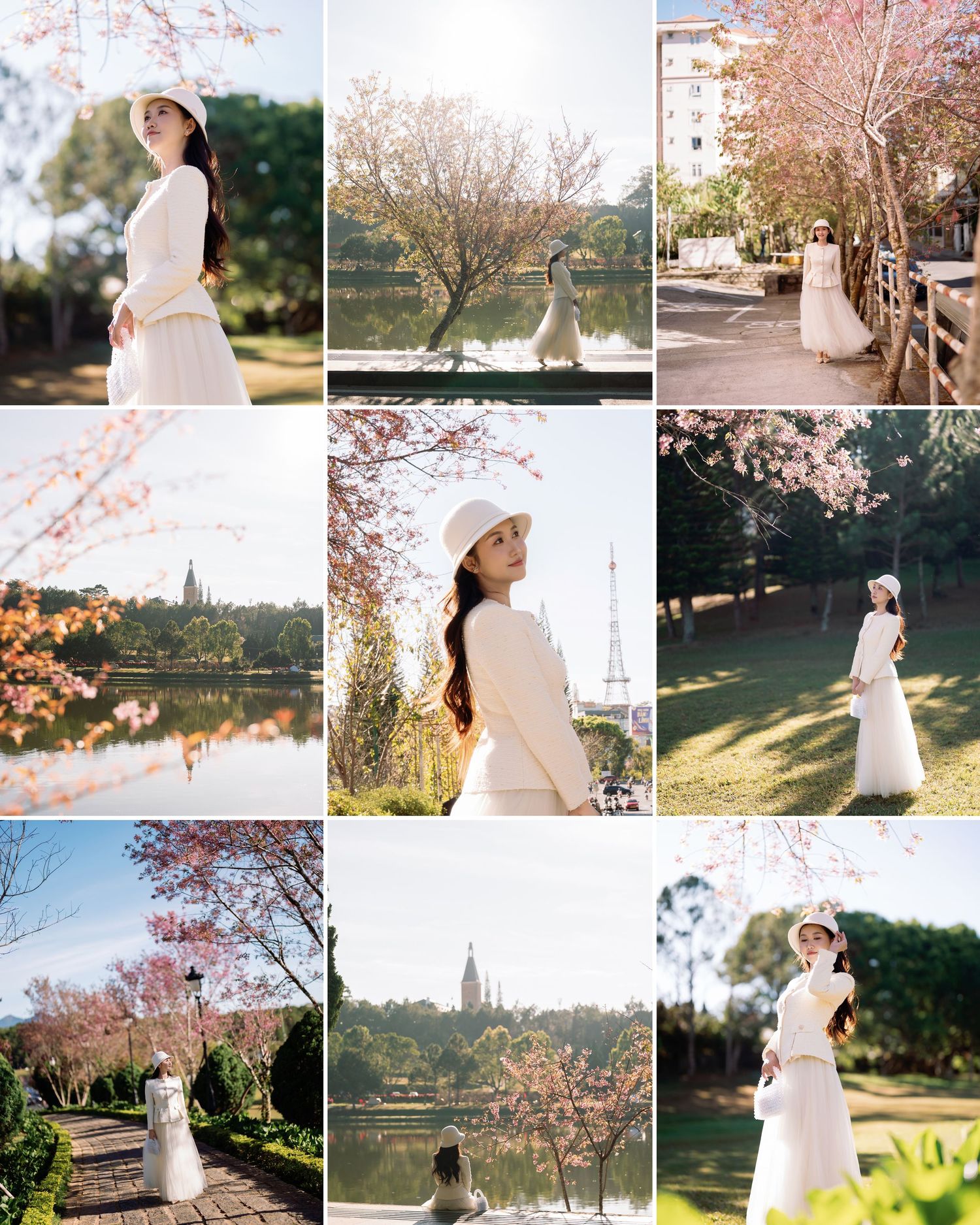 Woman in white dress and hat poses gracefully among pink cherry blossom trees by a serene lake in a lush park.