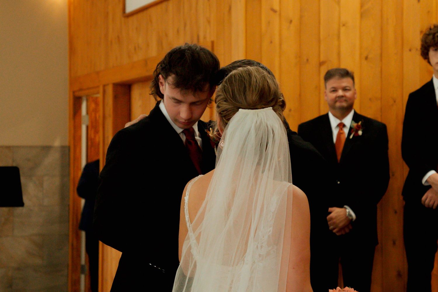 A groom leans in close to his bride during an intimate wedding ceremony moment at the altar.
