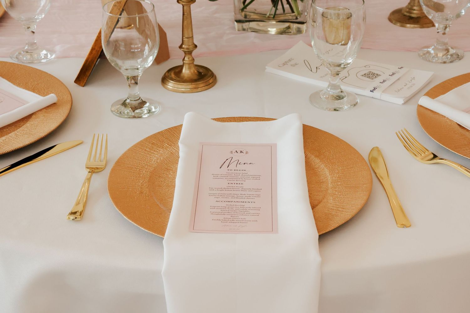 Gold charger plate with blush pink menu card and gold flatware at elegant wedding reception table.