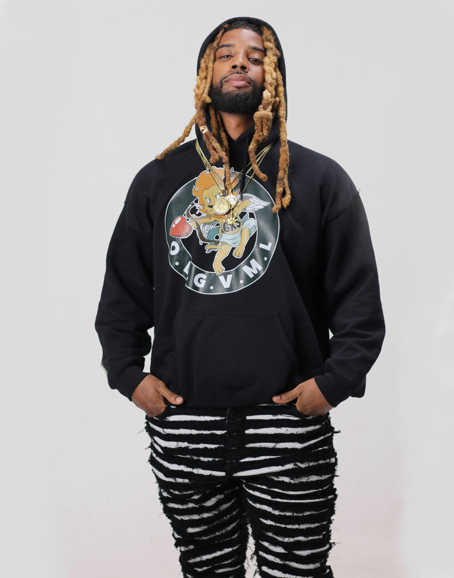 Man with blonde dreadlocks wearing black OGVM graphic hoodie and zebra print pants.