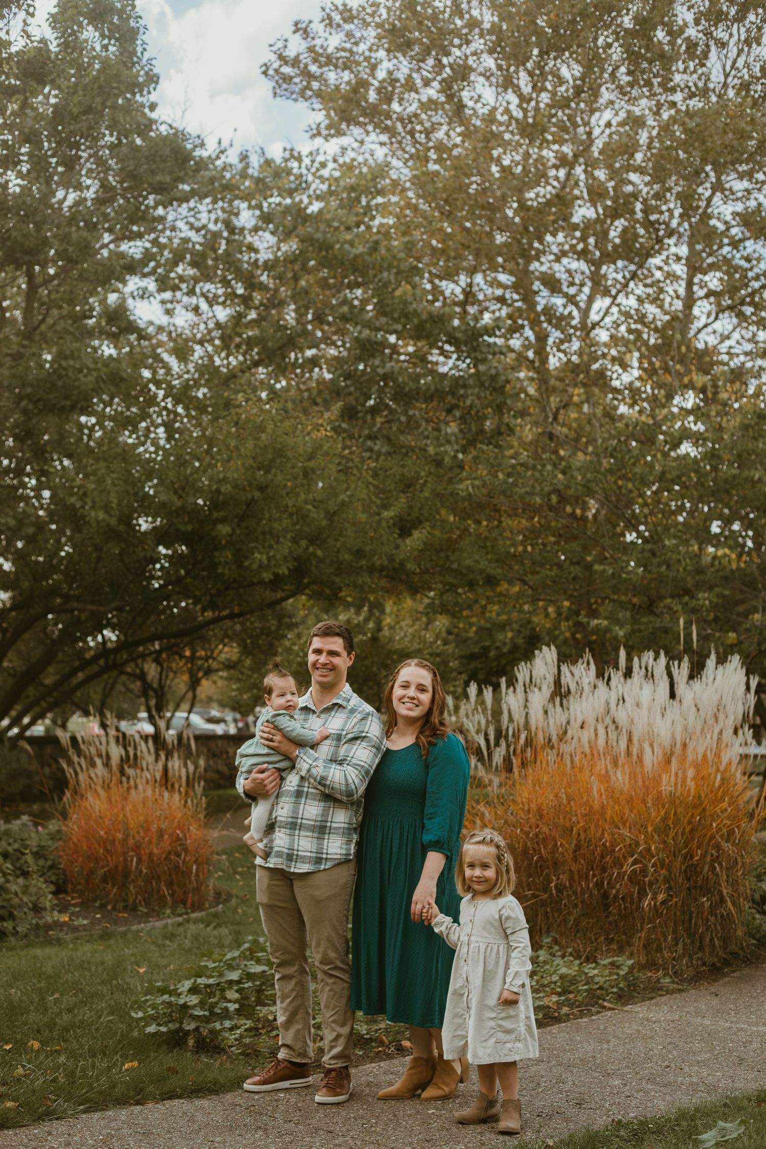 Family of four standing and smiling.