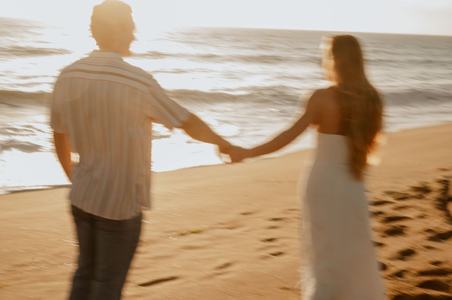 Romantic engagement photo of couple during golden hour at Newport Beach with an ocean background