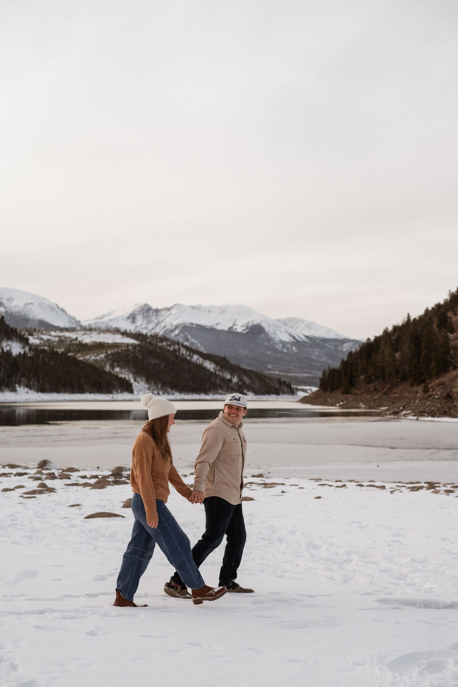 A couple shares a loving moment in the picturesque beauty of Breckenridge, with stunning mountains and snow as the perfect backdrop