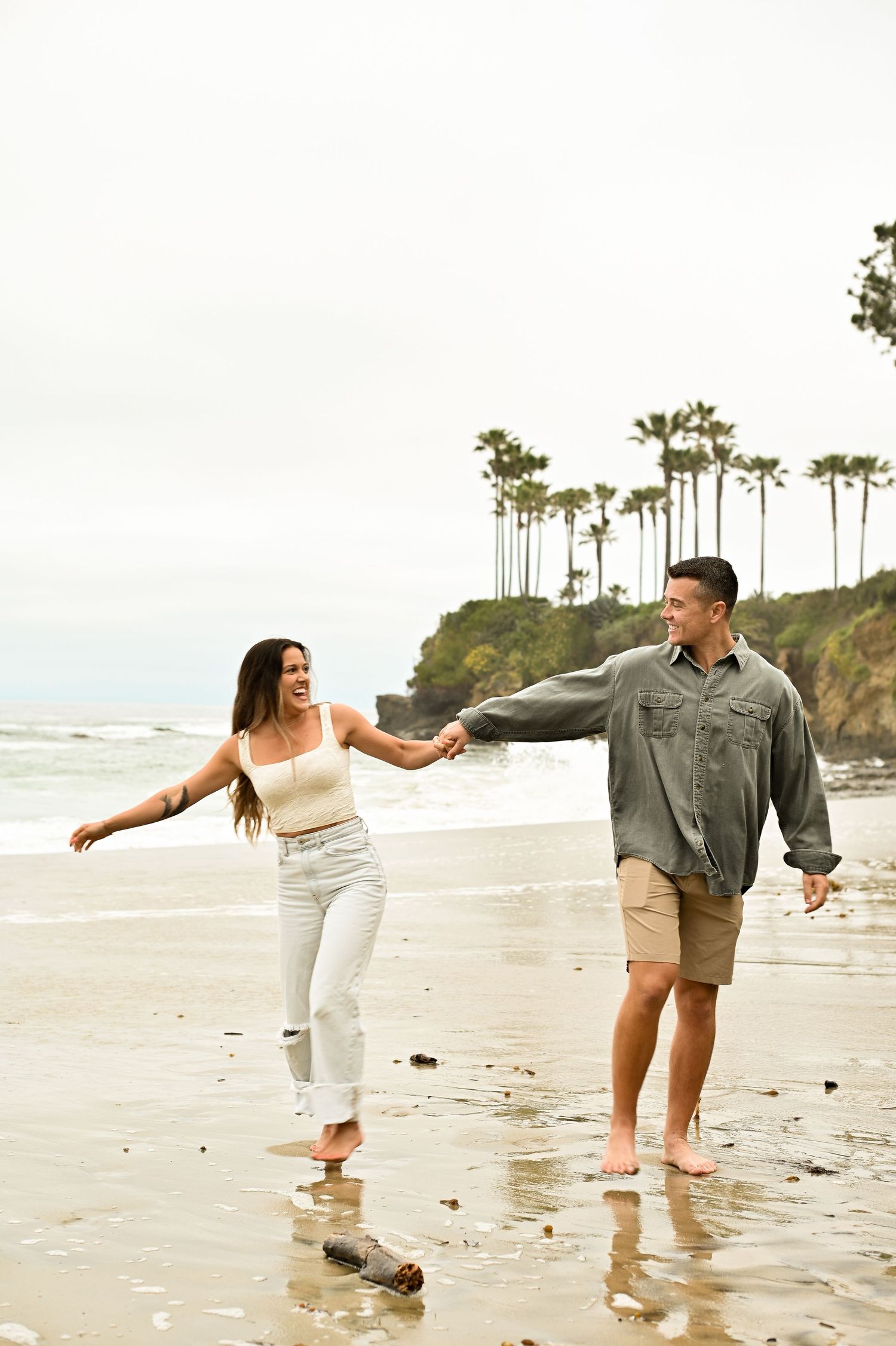 Engagement photo of couple embracing with golden sunset light at Newport Beach, California