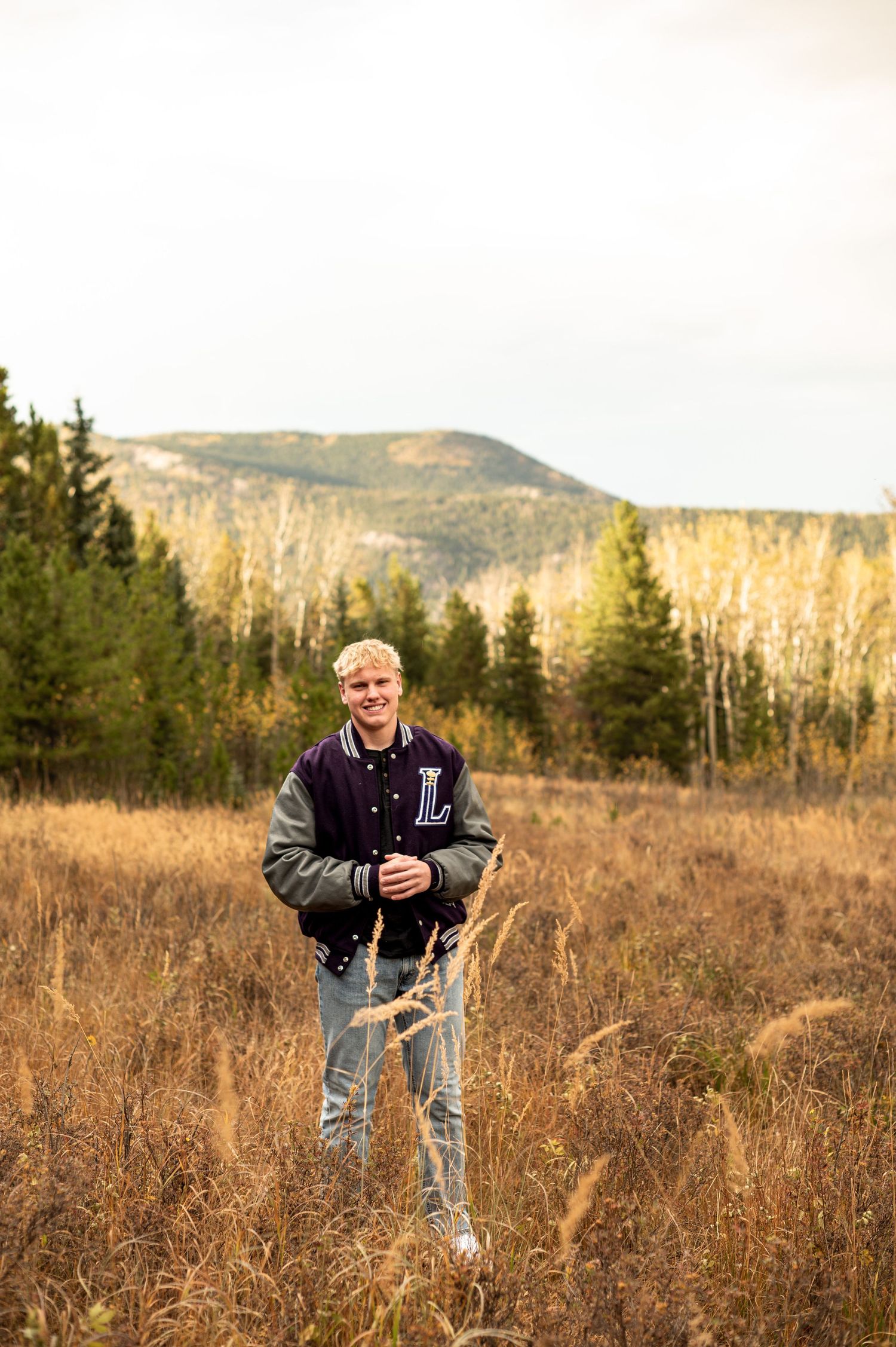 Confident senior guy stands tall against Colorado’s stunning backdrop, ready to take on the future with a bold, adventurous spirit.
