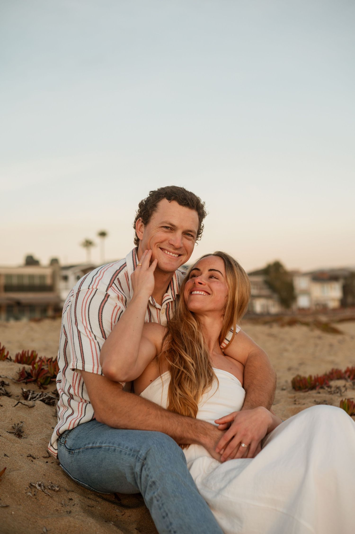 Romantic engagement photo of couple during golden hour at Newport Beach with an ocean background