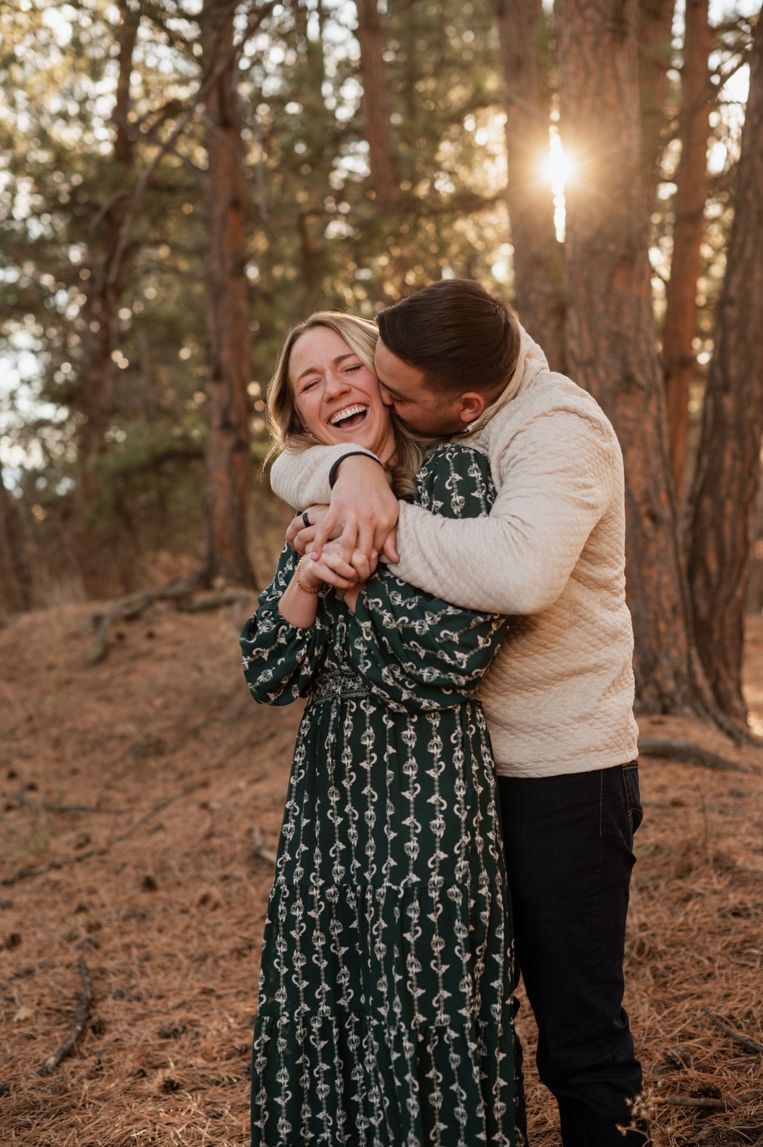 A couple shares a loving moment in the picturesque beauty of castle pines, with stunning mountains and pine trees as the perfect backdrop