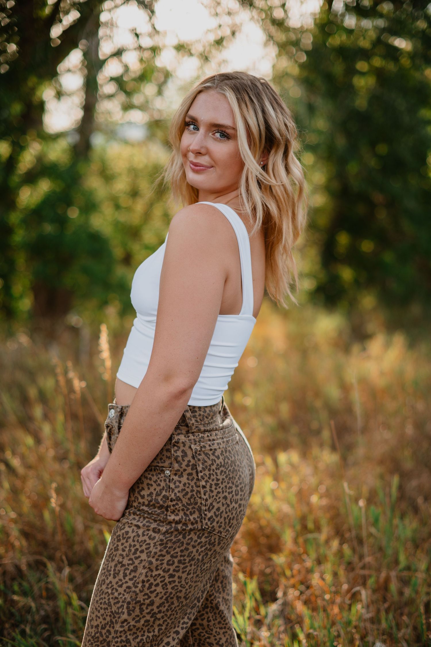 A senior girl shines in her cute outfit, with her blonde hair glowing against the scenic beauty of Littleton, Colorado—capturing her vibrant