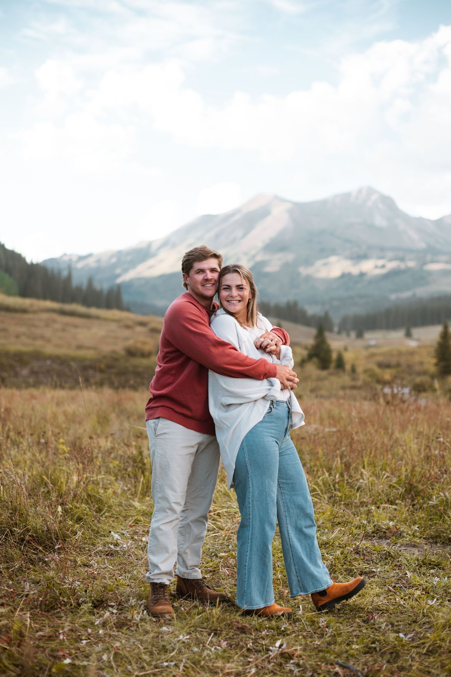 A couple shares a loving moment in the picturesque beauty of Crested Butte, with stunning mountains and wildflowers as the perfect backdrop