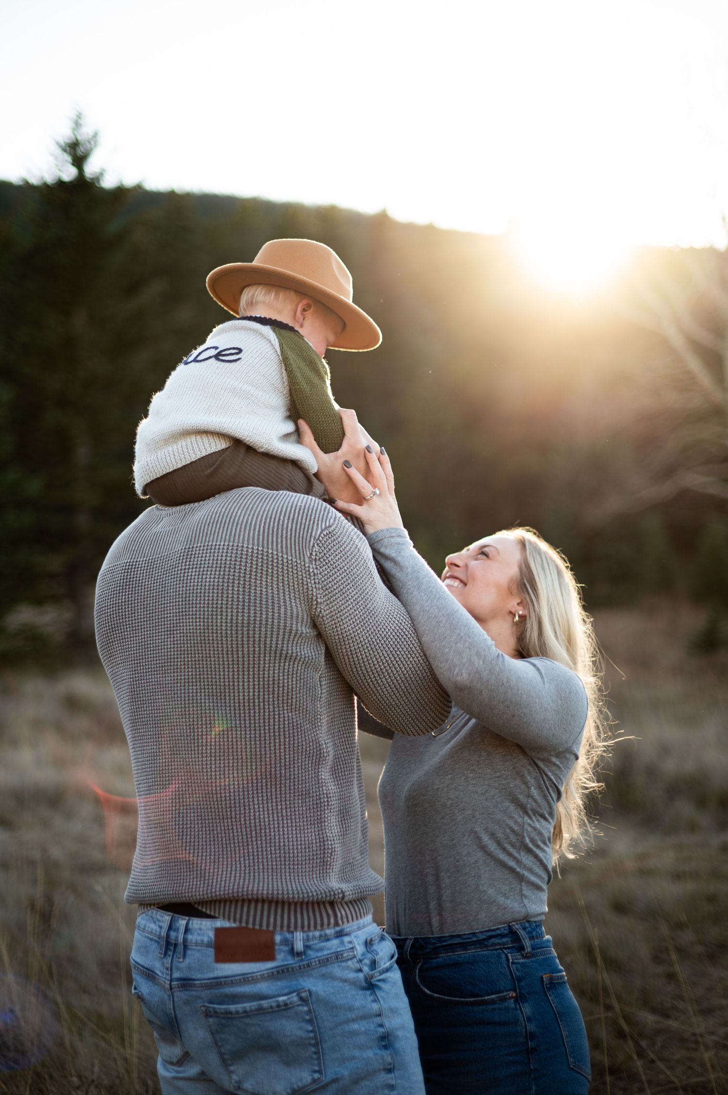 A joyful family enjoys golden hour in evergreen, bathed in warm sunlight, capturing their love and connection against Colorado’s stunning