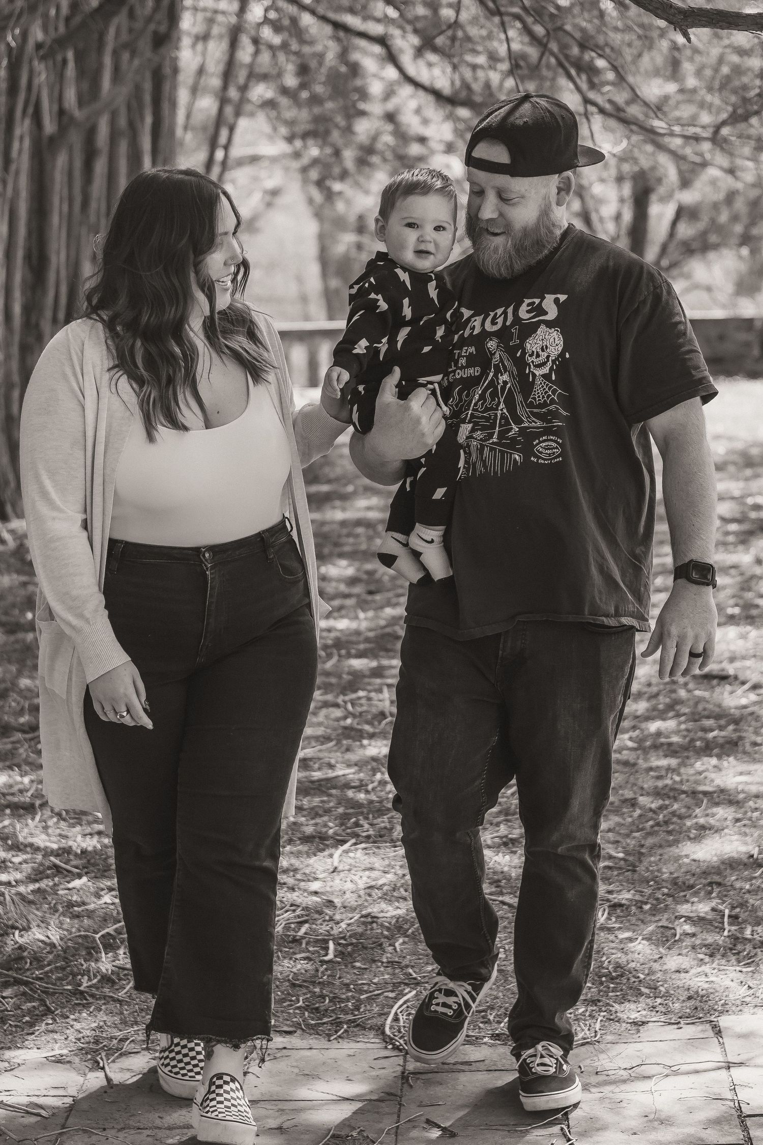 Family enjoying quality time together on wooded path in black and white.