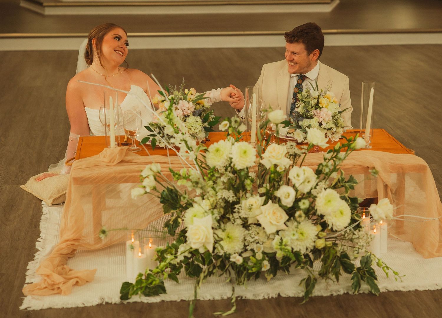 Elegant blush and white floral wedding centerpiece arrangement set on tables for a formal reception.