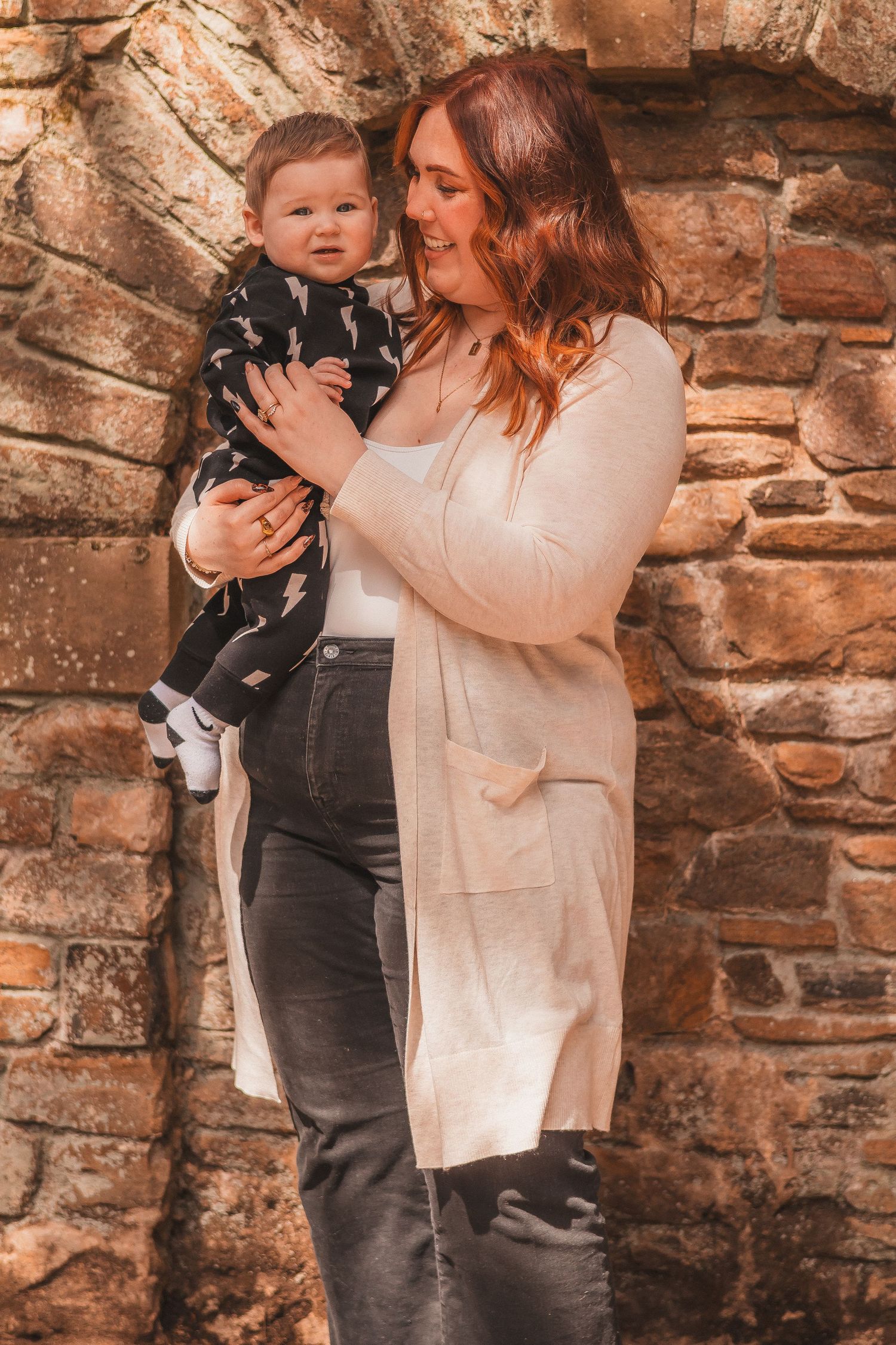 A tender family moment captured against a rustic stone wall background.