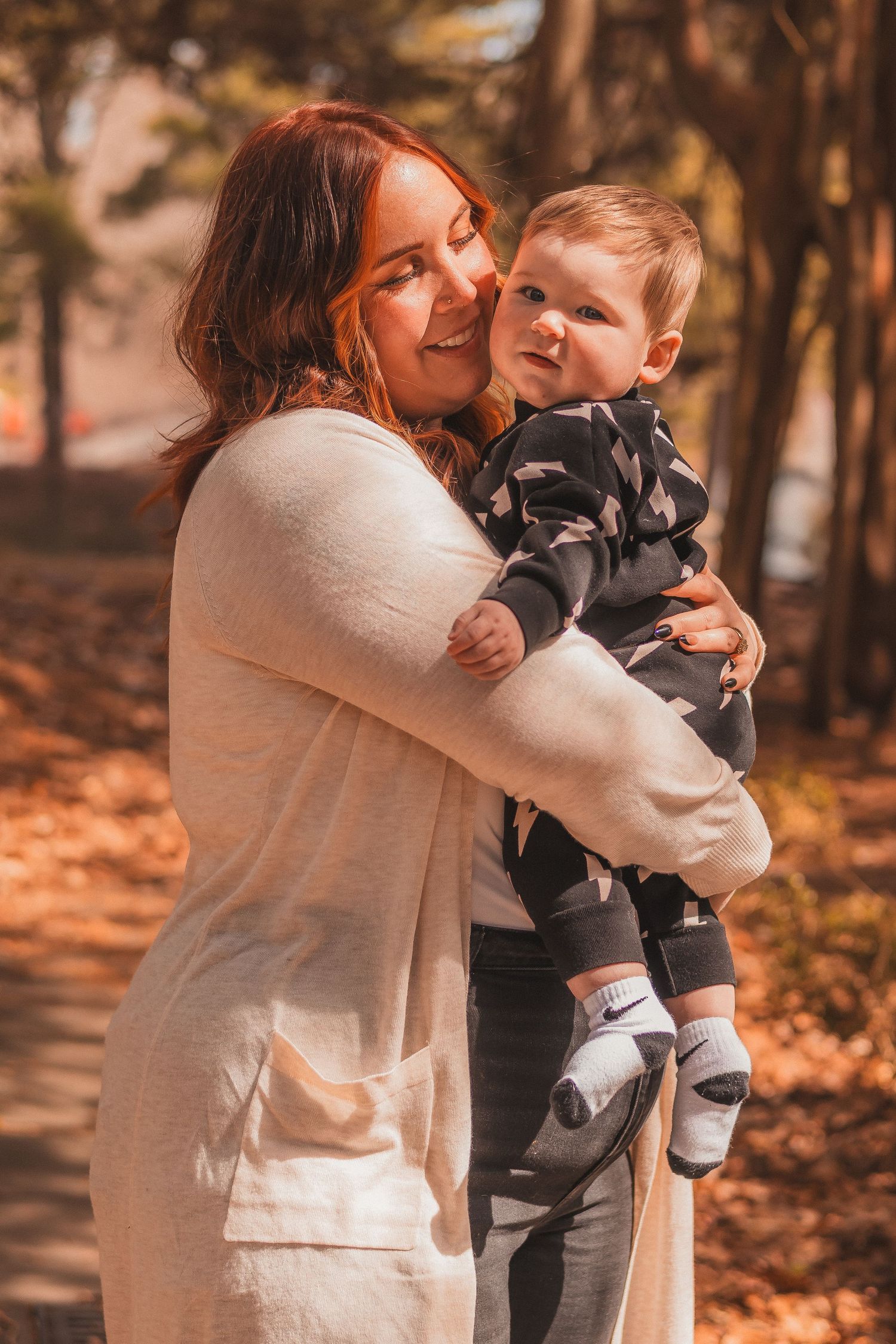 Parent and child share joyful moment outdoors during fall season.