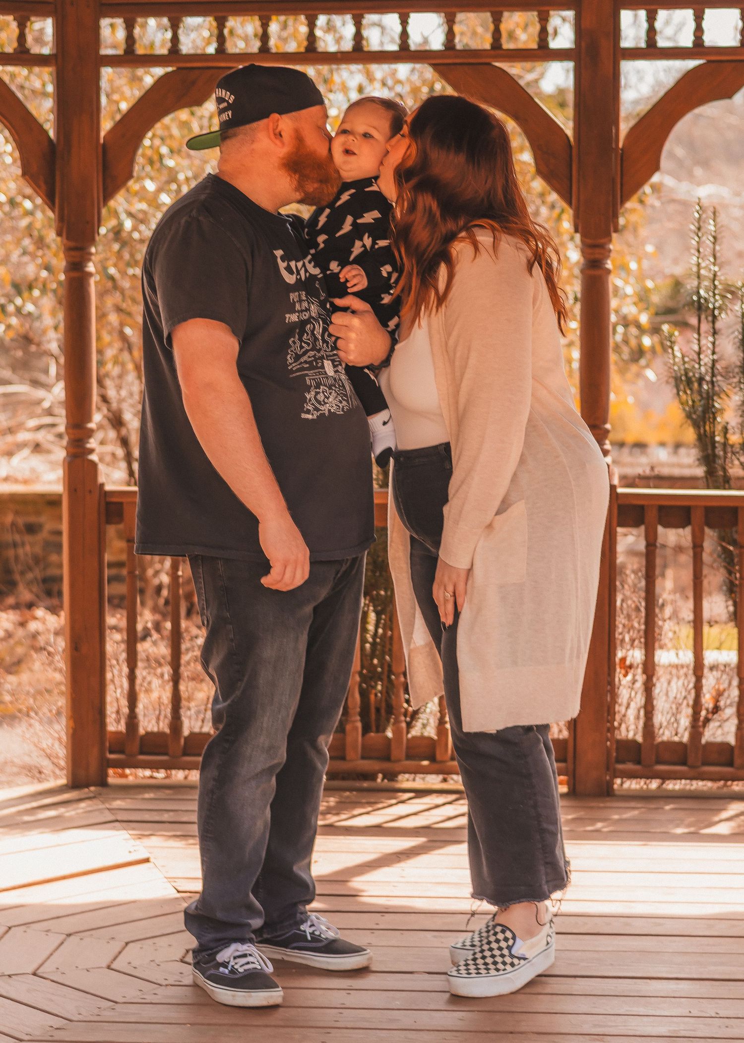 A family sharing an intimate moment in a wooden gazebo with golden light filtering through.