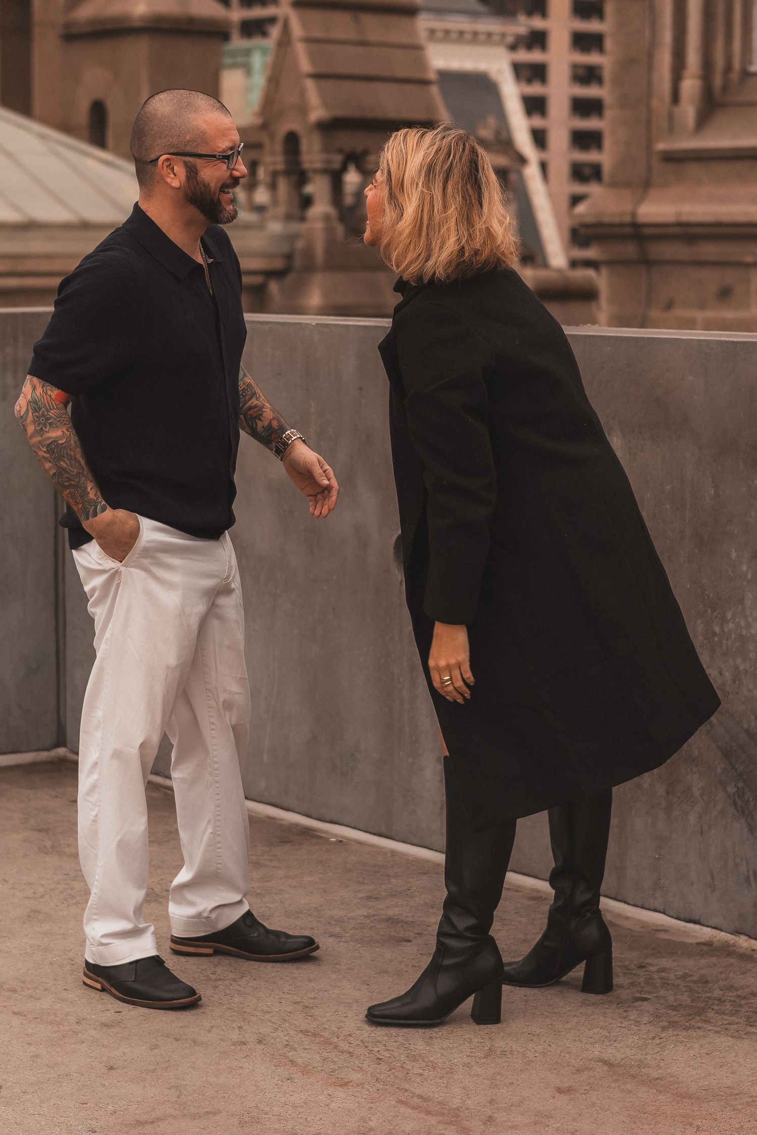 Stylish couple in casual wear having conversation near ornate church building.