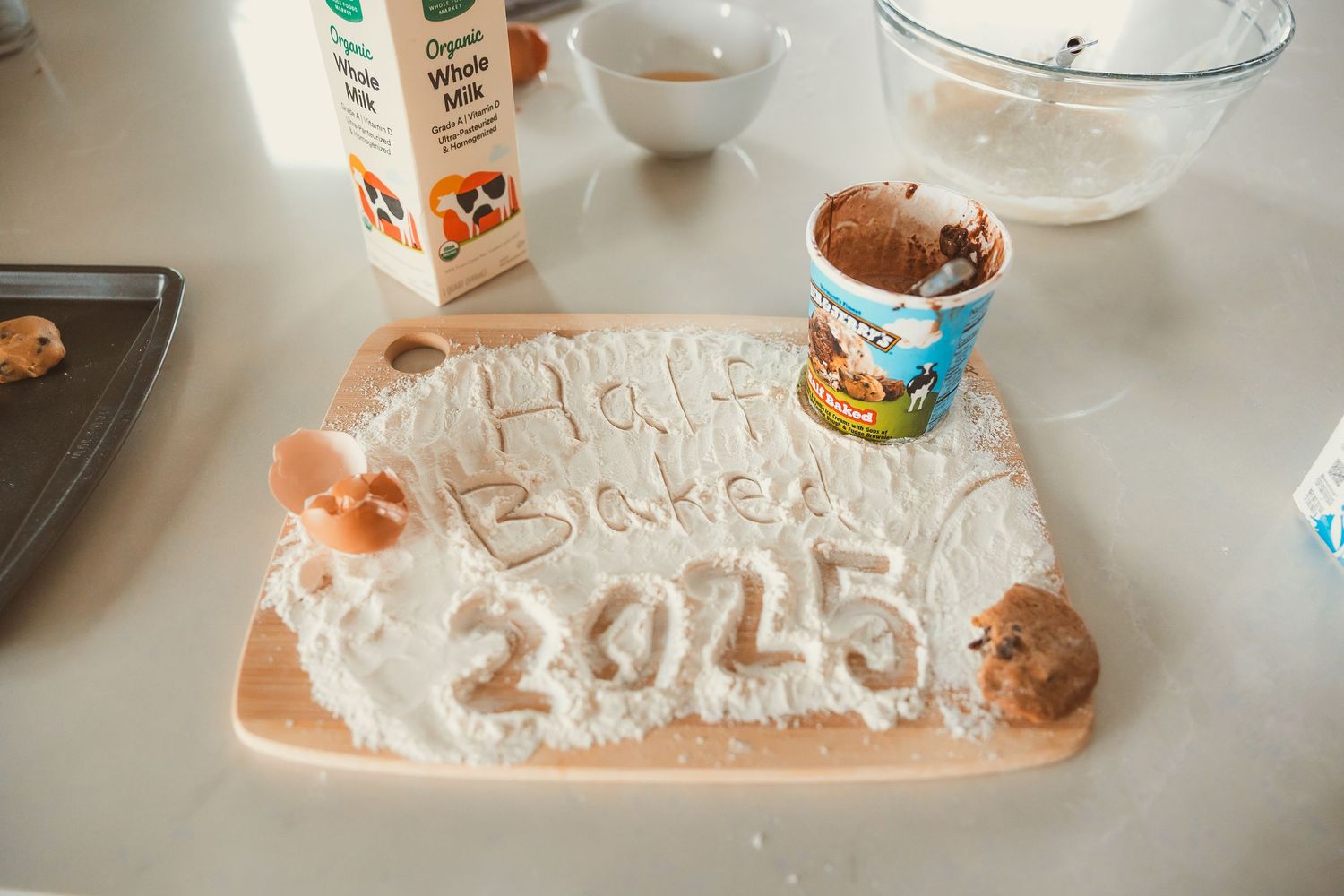 A rustic flour-dusted surface with 'Happy Birthday 2015' written on it alongside some cookie dough and baking supplies.