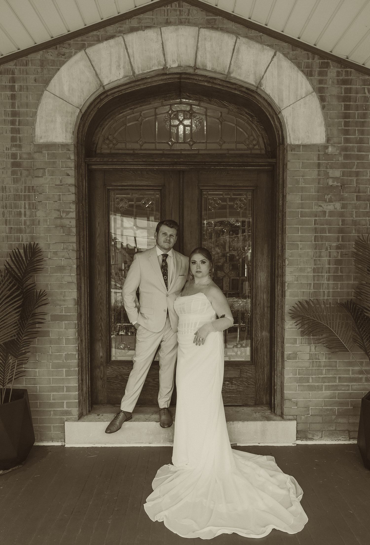 A series of sepia-toned wedding photos taken under a brick archway entrance with elegant poses.