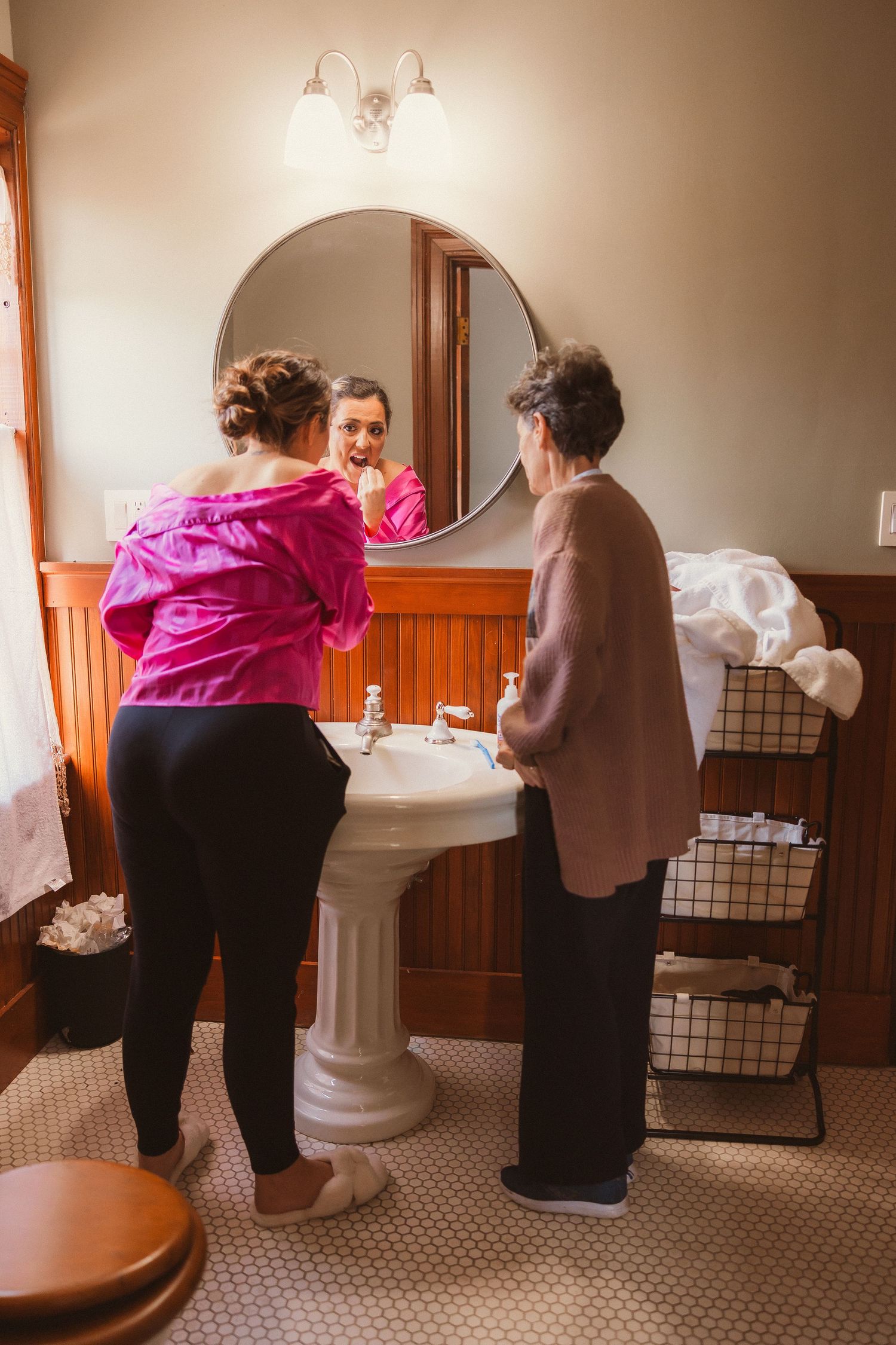 Interior view of people getting ready in a vintage-style bathroom with wooden accents.