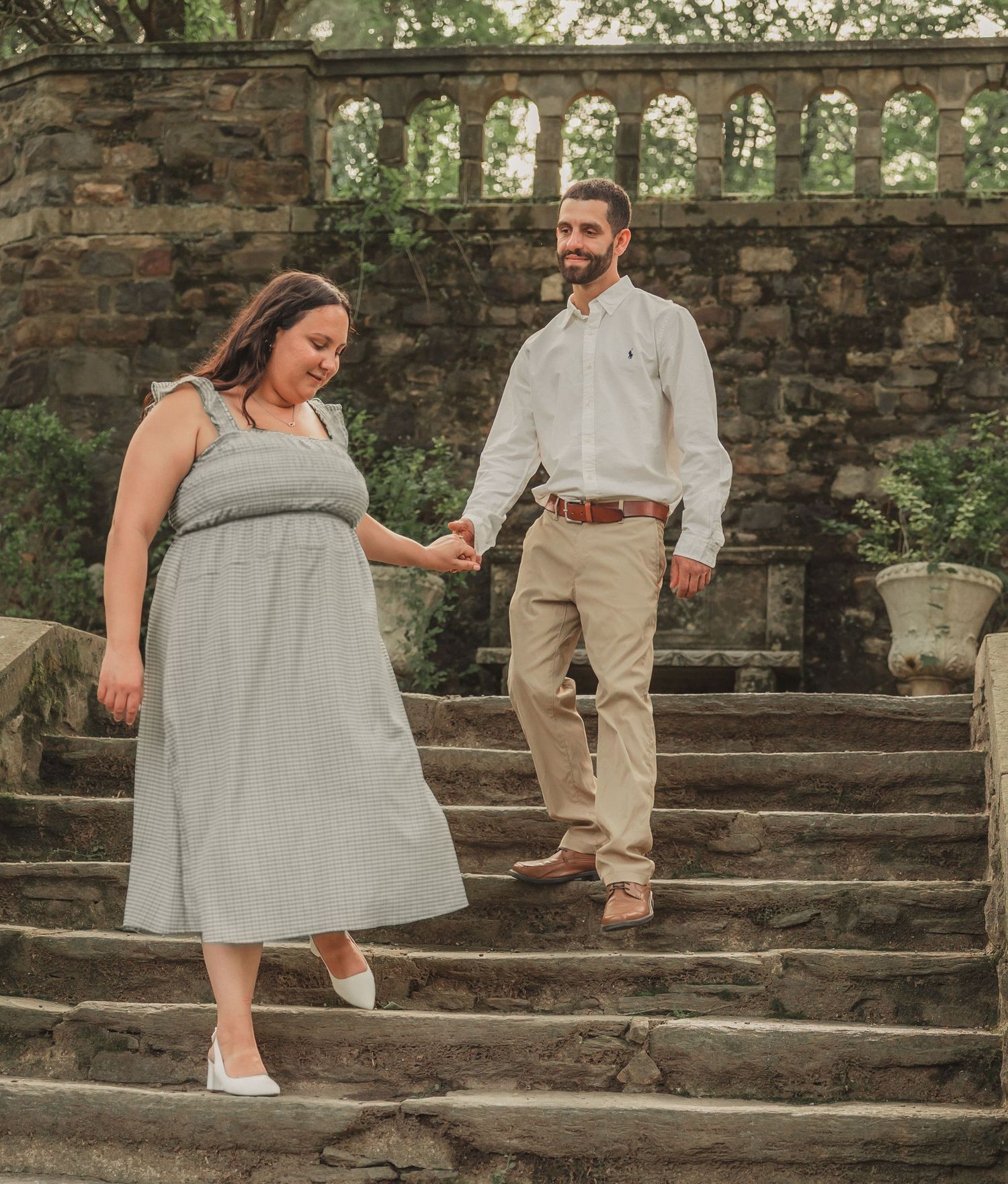 A couple in light-colored attire ascends stone steps along a rustic wall in progressive action shots.