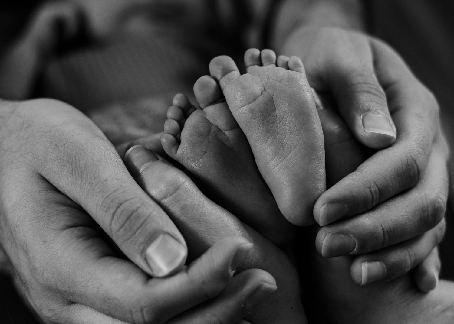 newborn feet with parents hands