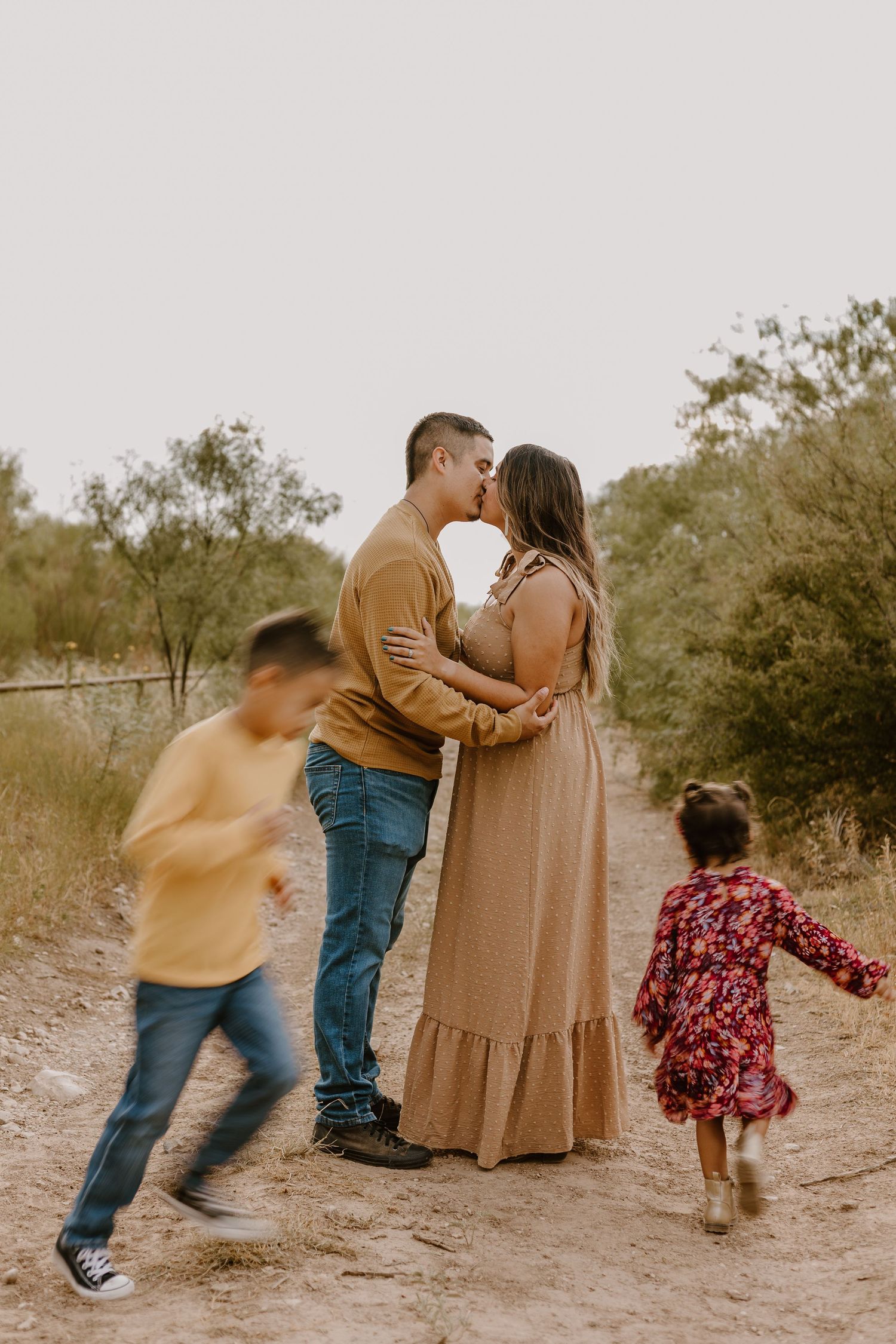 mom and dad with kids running around them